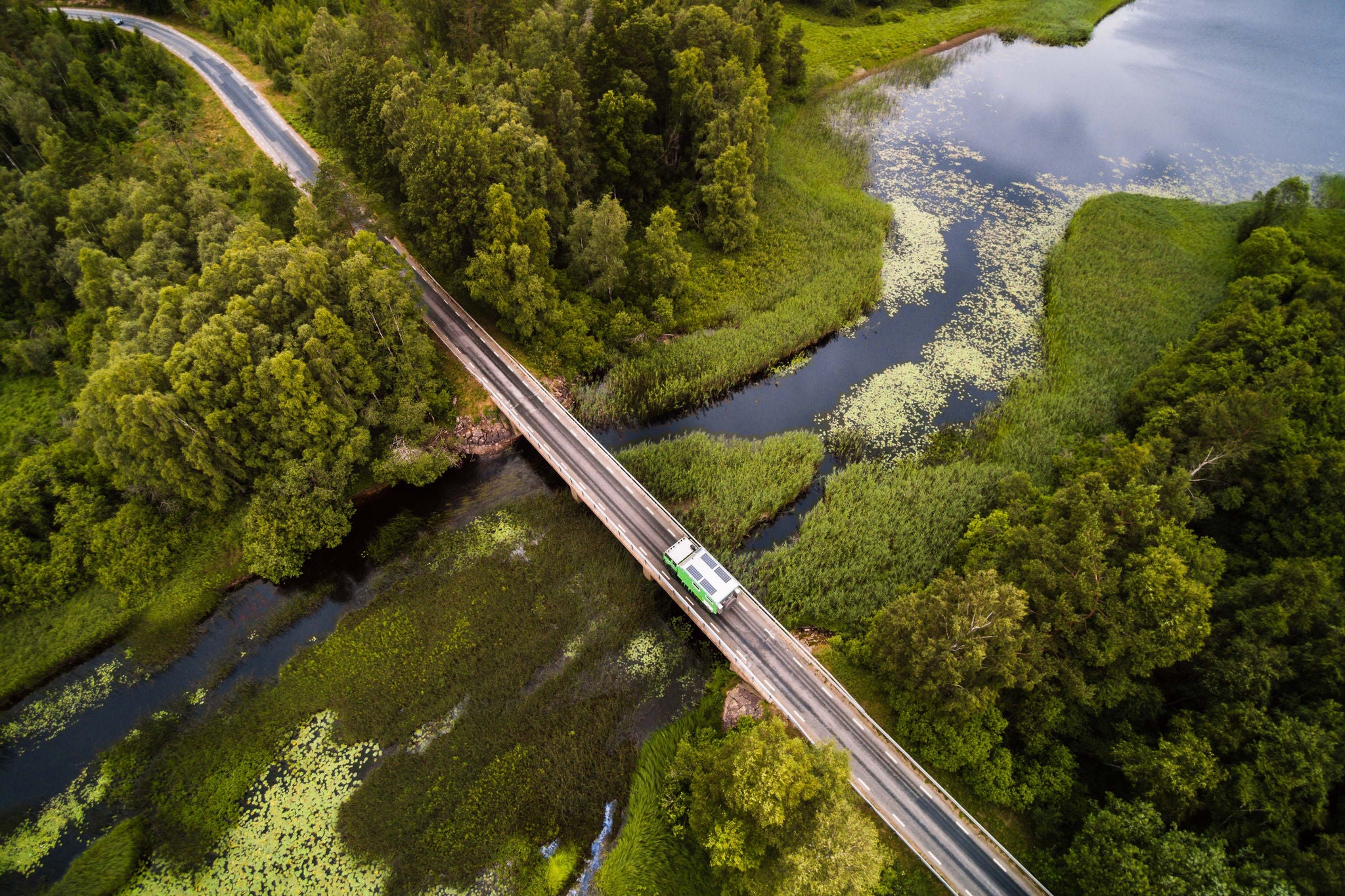 RV ovanifrån, på väg över en bro i ett svenskt vattenlandskap