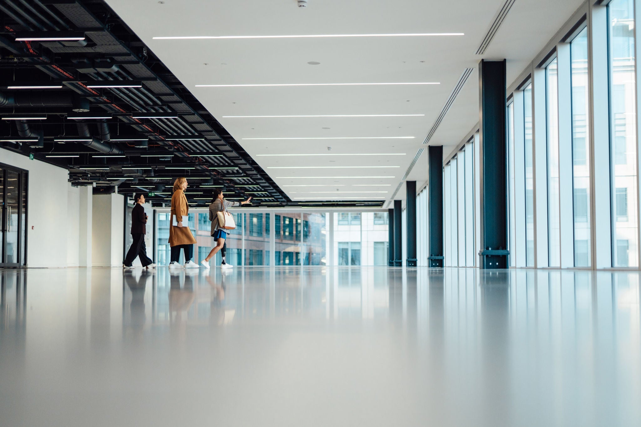Multi-racial group of businesswomen viewing new office space with an estate agent