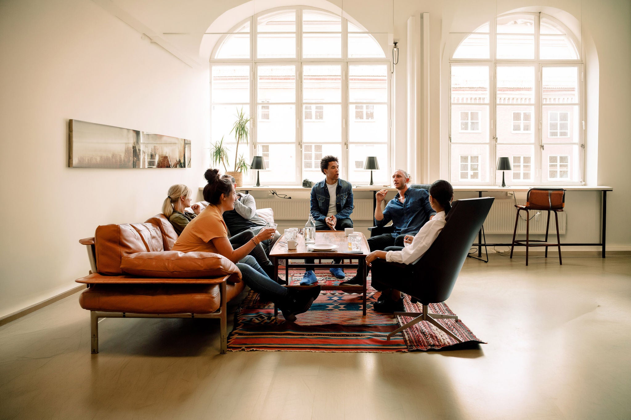 Creative male and female business colleagues talking during break in office