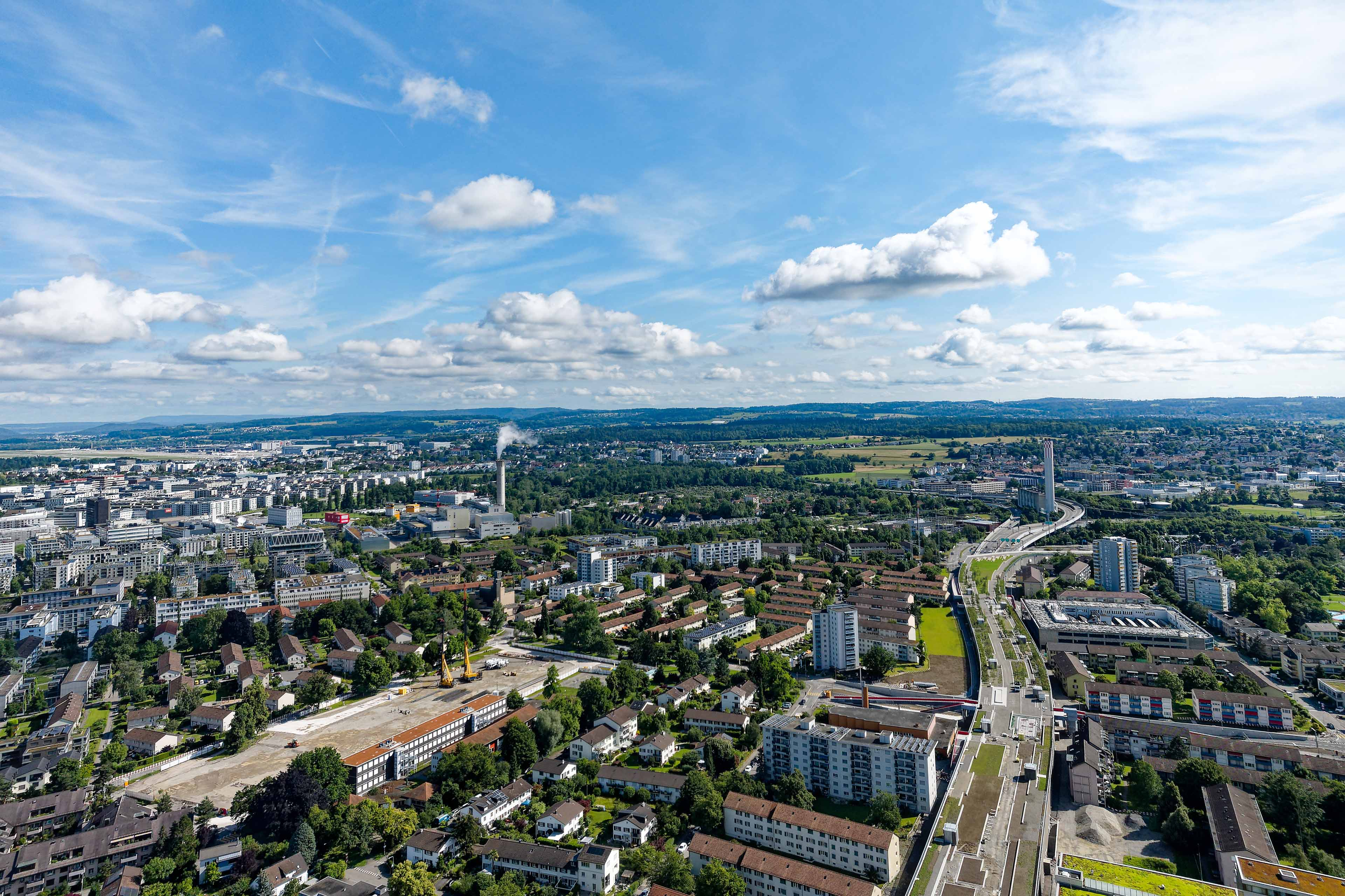 Aerial view of Swiss City of Zürich north part with highway enclosure construction site and public park on a sunny spring morning. Photo taken June 16th, 2024, Zurich, Switzerland.