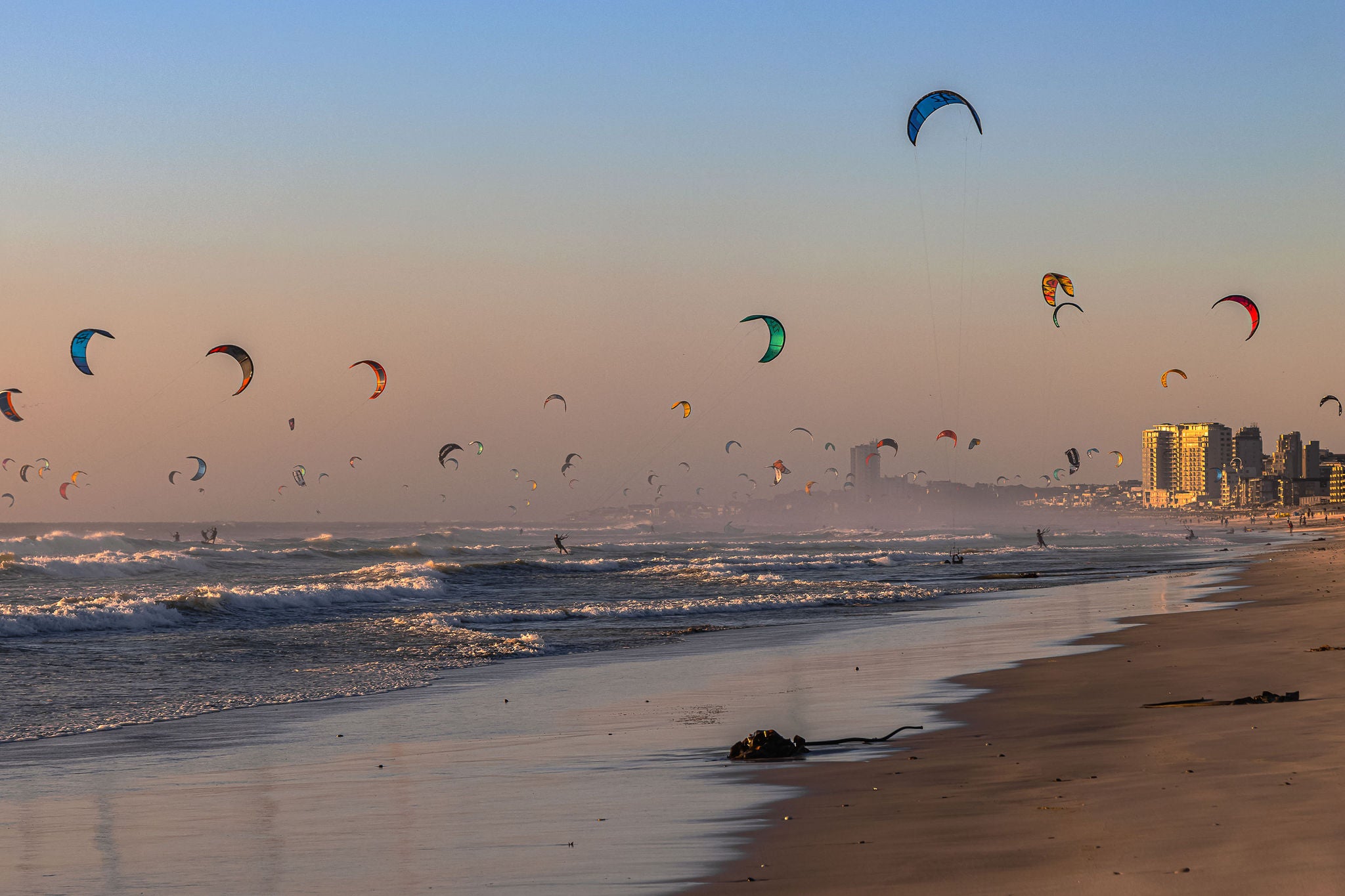 Group of people kite surfing seen from the beach