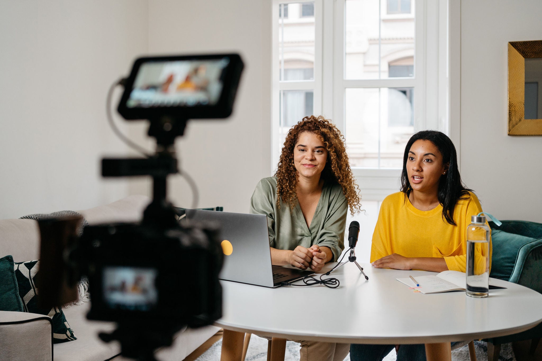 Two women recording podcast together