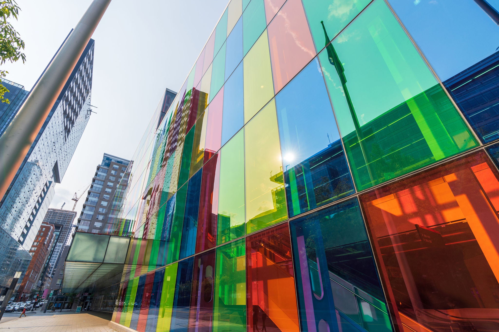 Colorful glass panels on a modern building facade reflecting the surrounding city