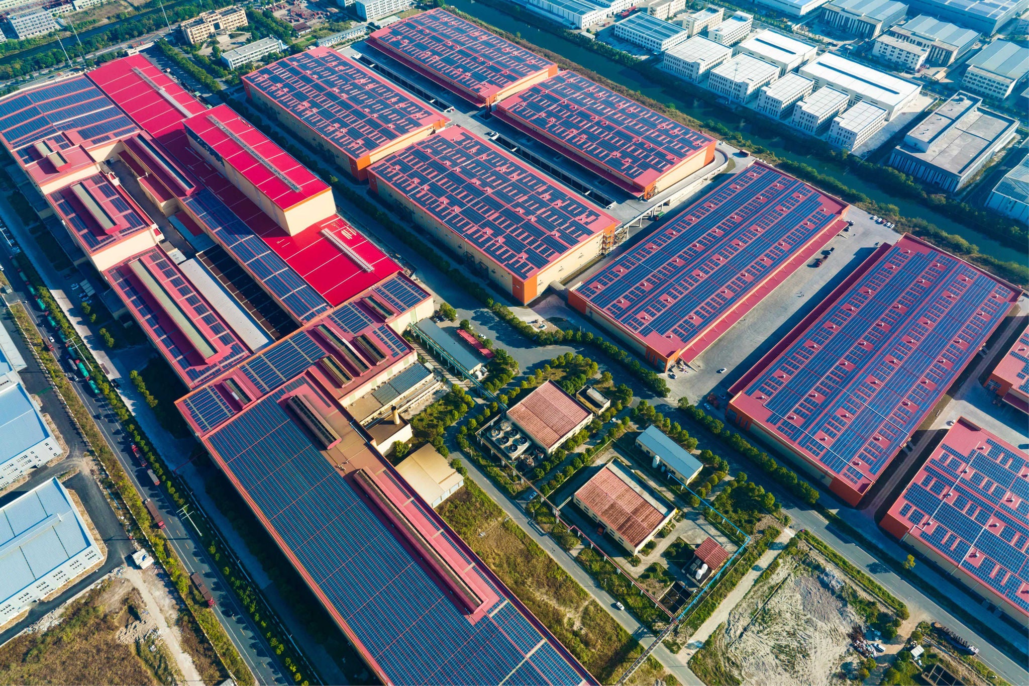 Farvestrålende solpaneler på industribygninger set oppefra 