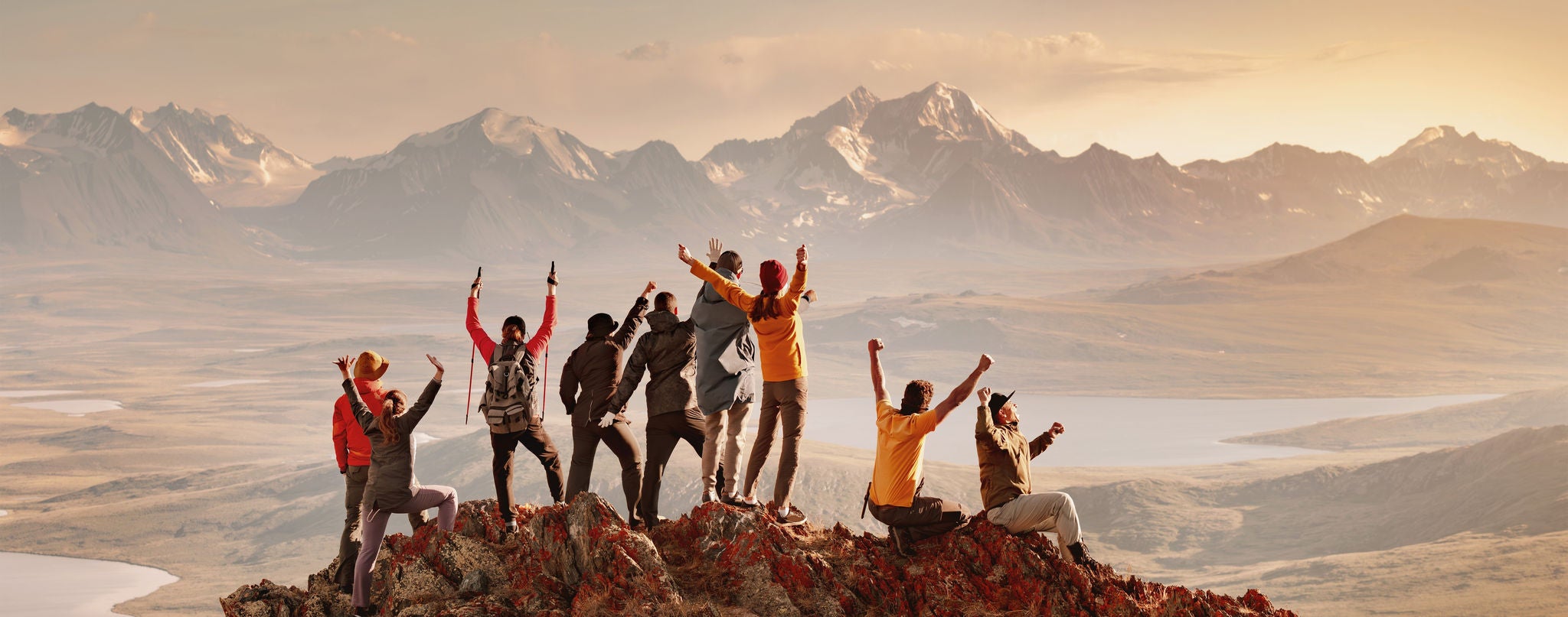 Big group of happy tourists are having fun and greeting sunset