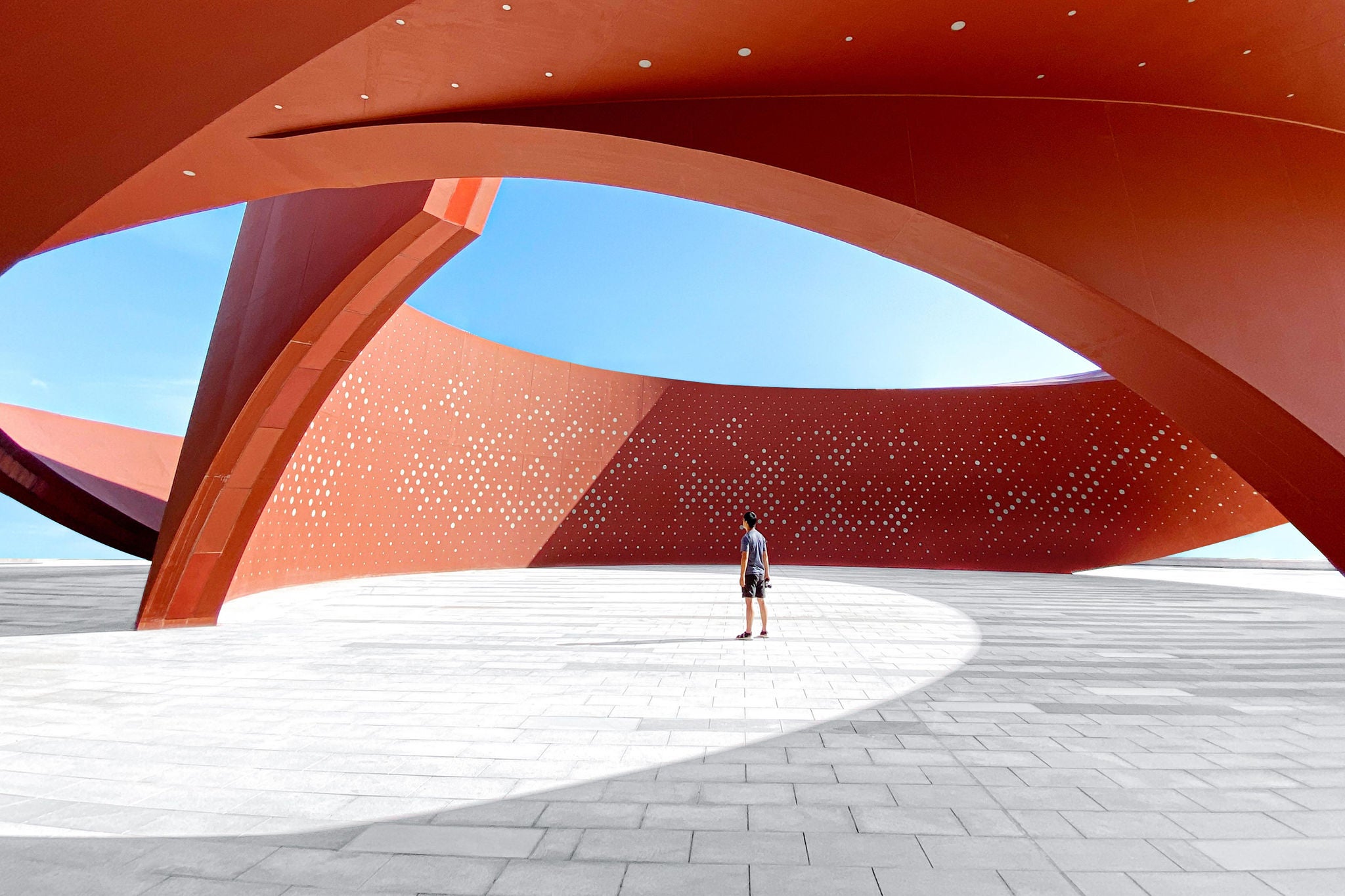 A person in a red curved abstract architectural space, 3D rendering