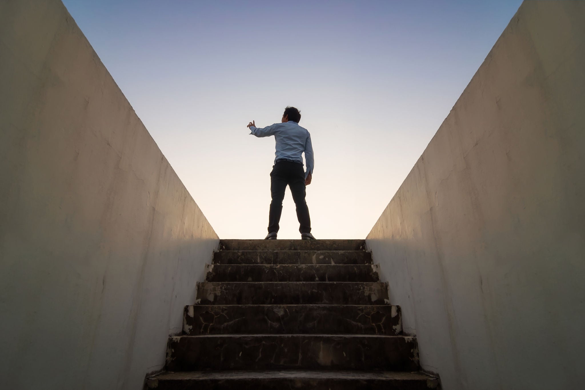 Low angle view of man standing on staircase against sky