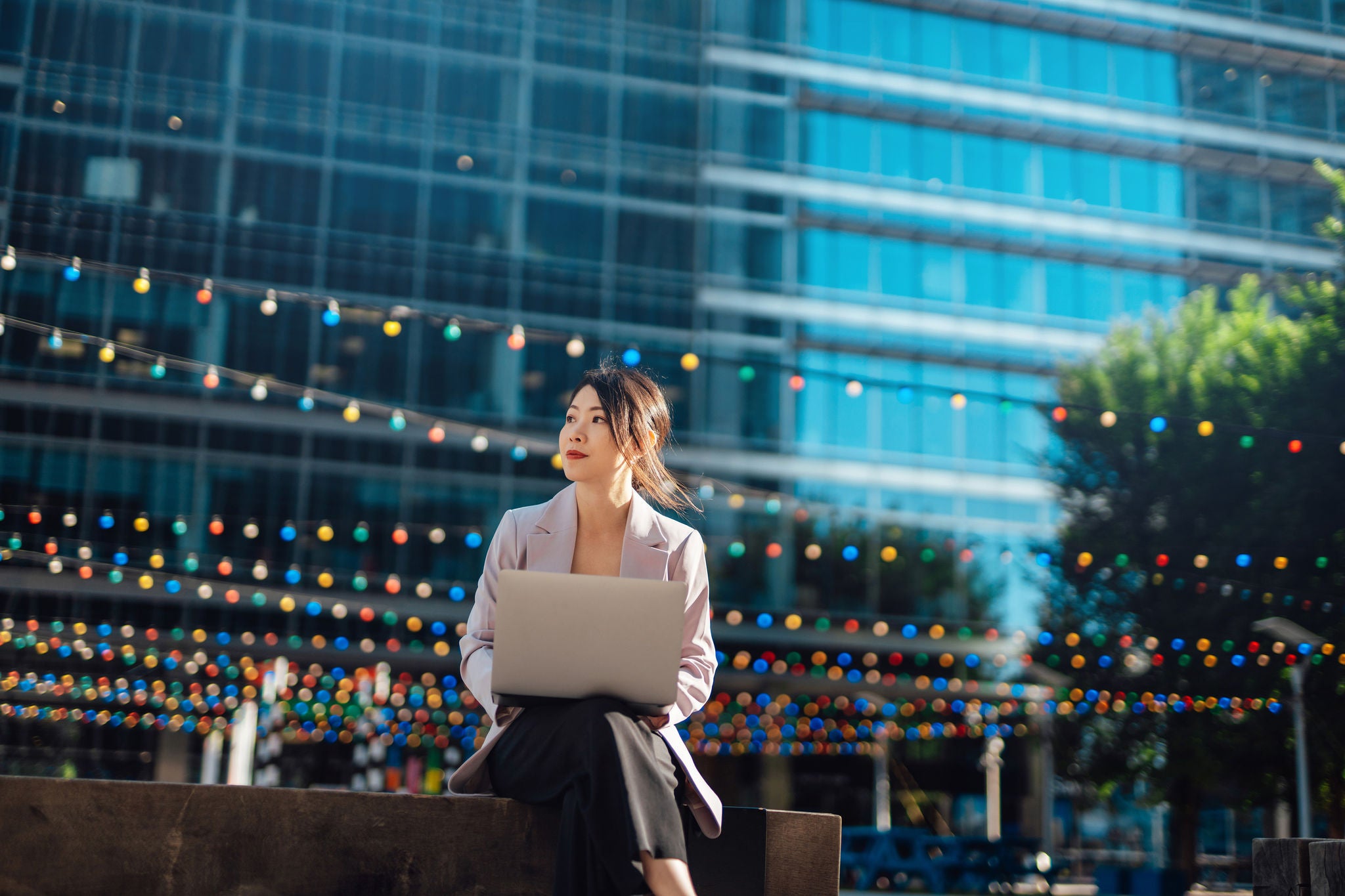Portrait of Asian business woman in financial district with laptop. Young entrepreneur. Employment opportunity.