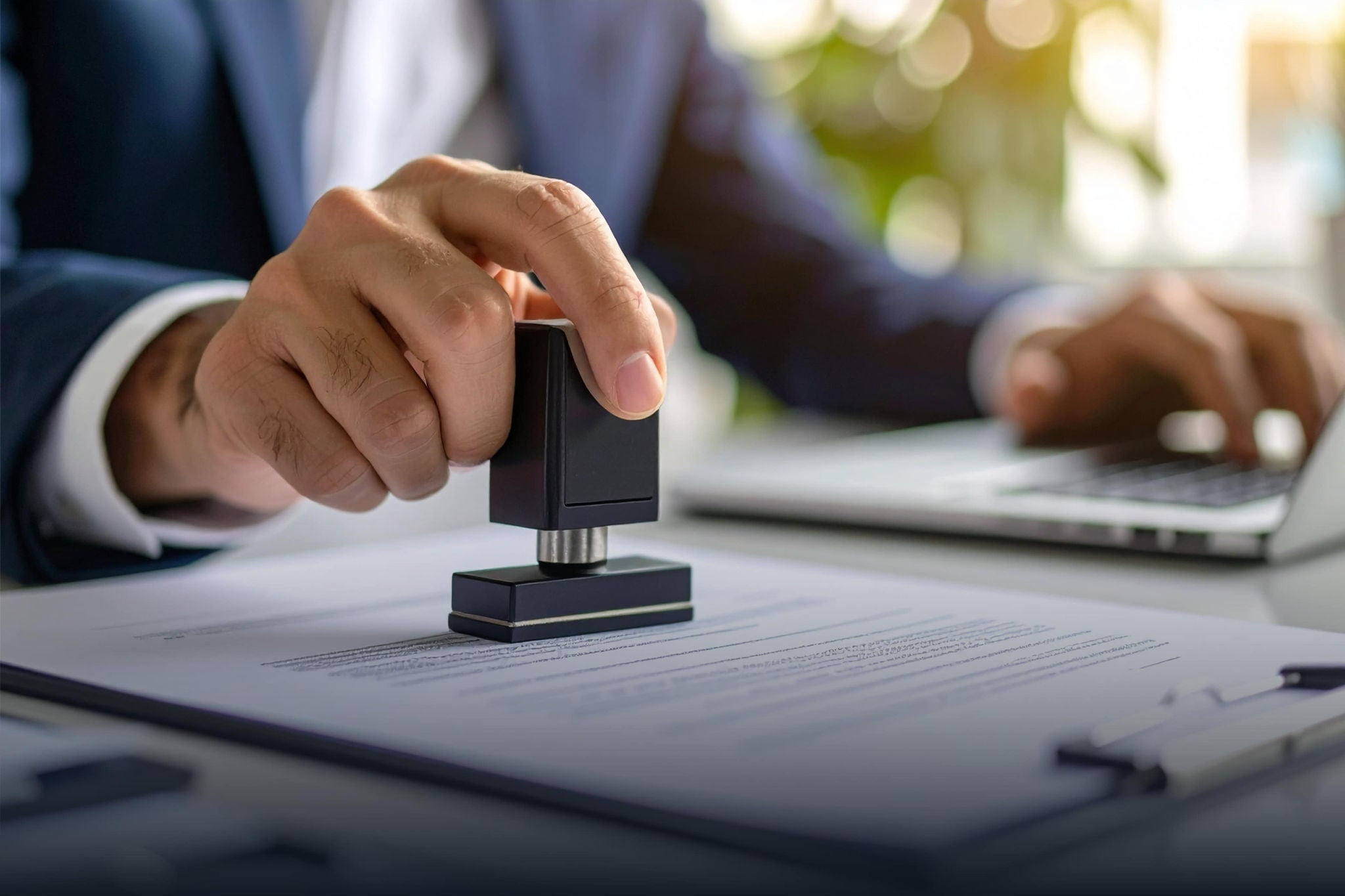 A smiling young woman with headphones and folders, standing outdoors on a college campus.