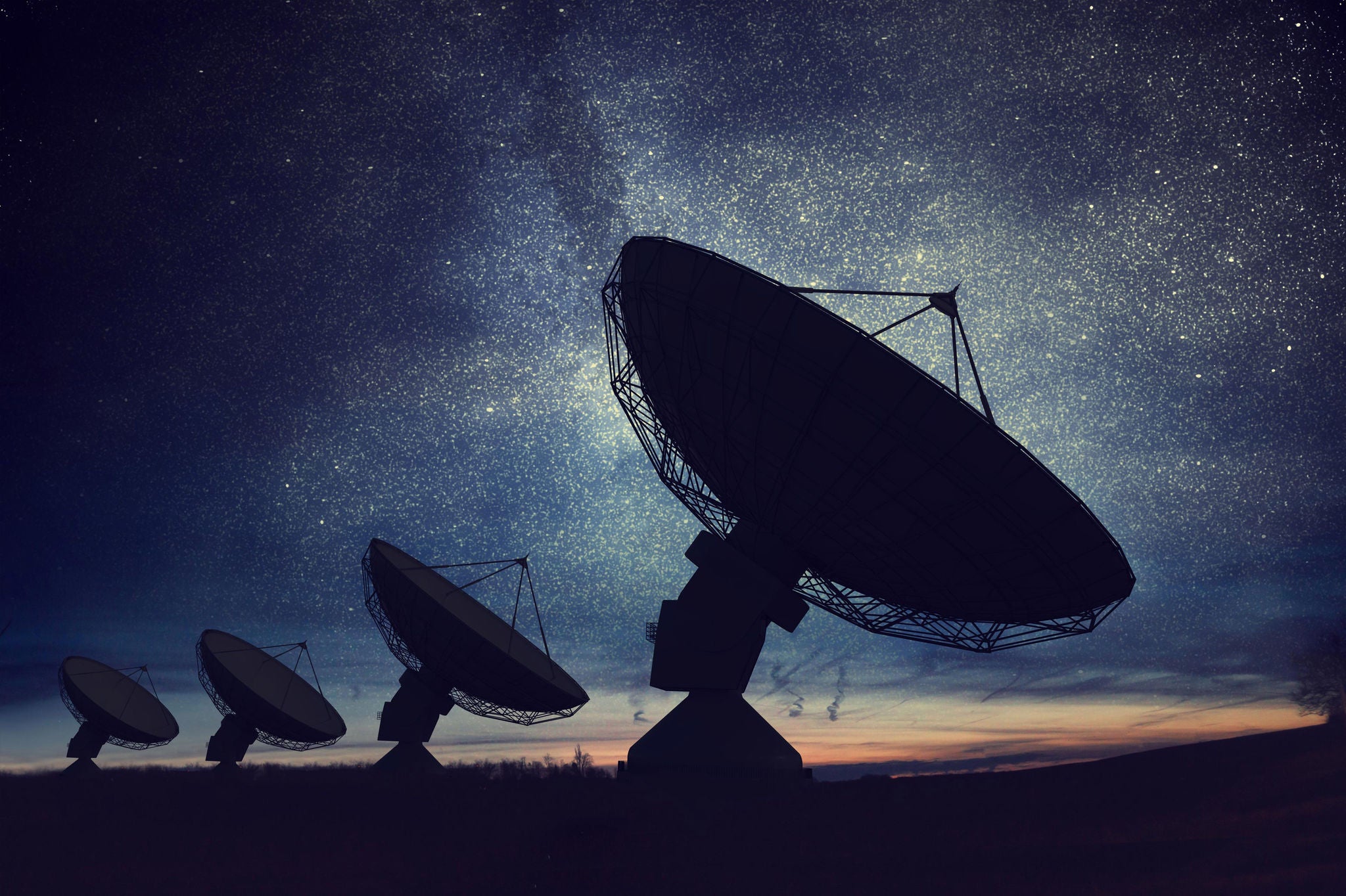 Satellite dishes or radio antennas against night sky 