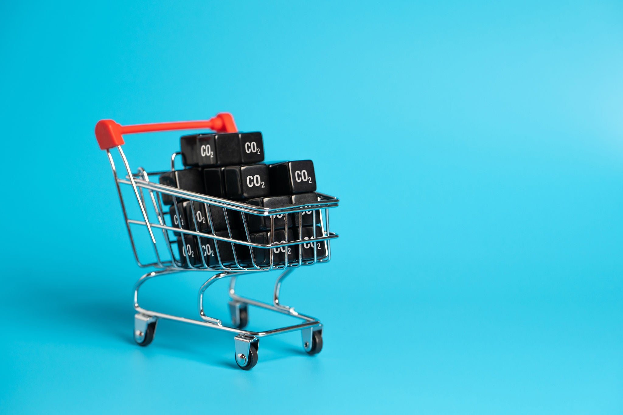Chariot contenant des cubes noirs marqués CO2 sur un fond bleu