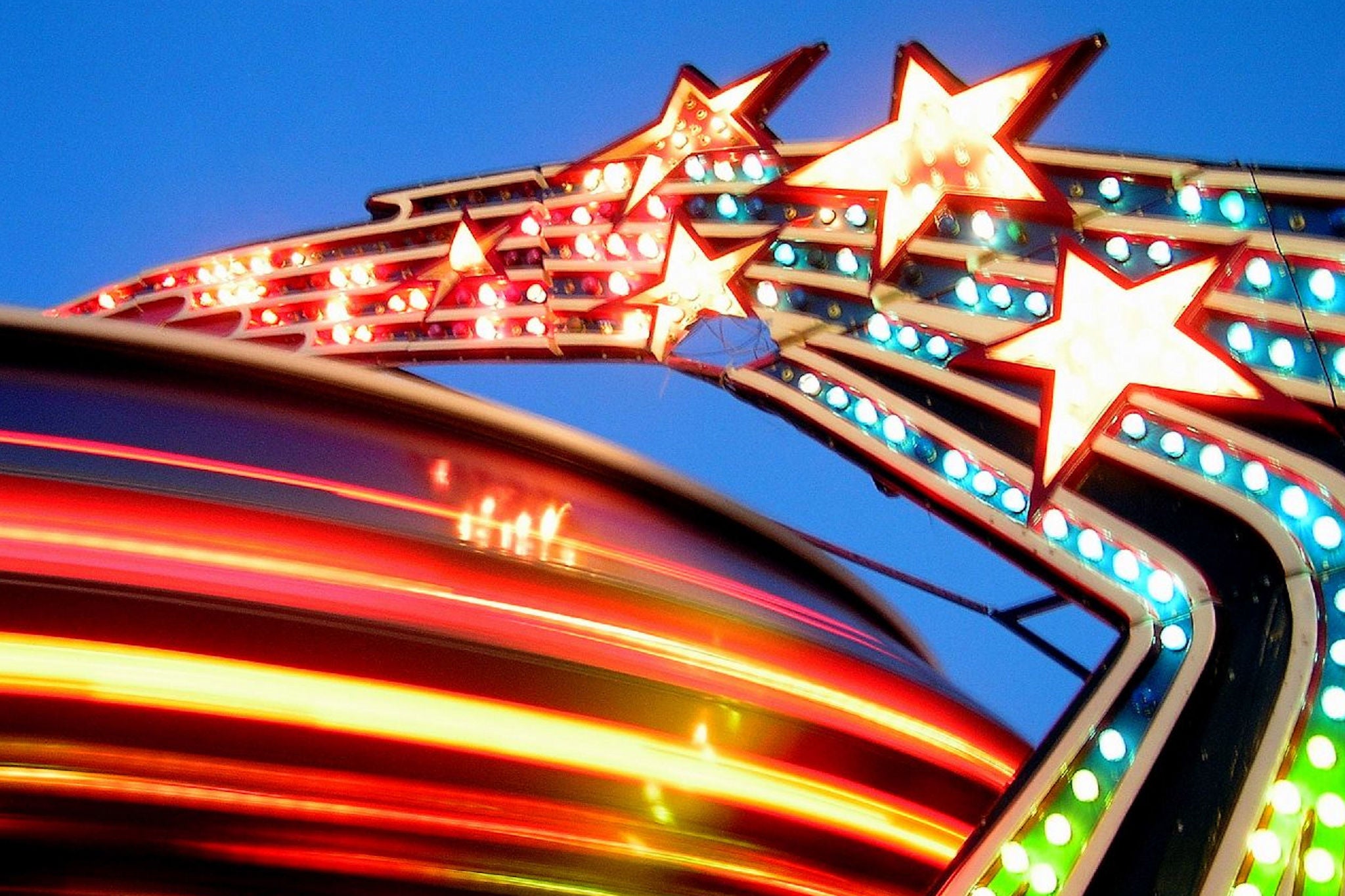 Vibrant carnival ride with star lights and dynamic motion blur at night