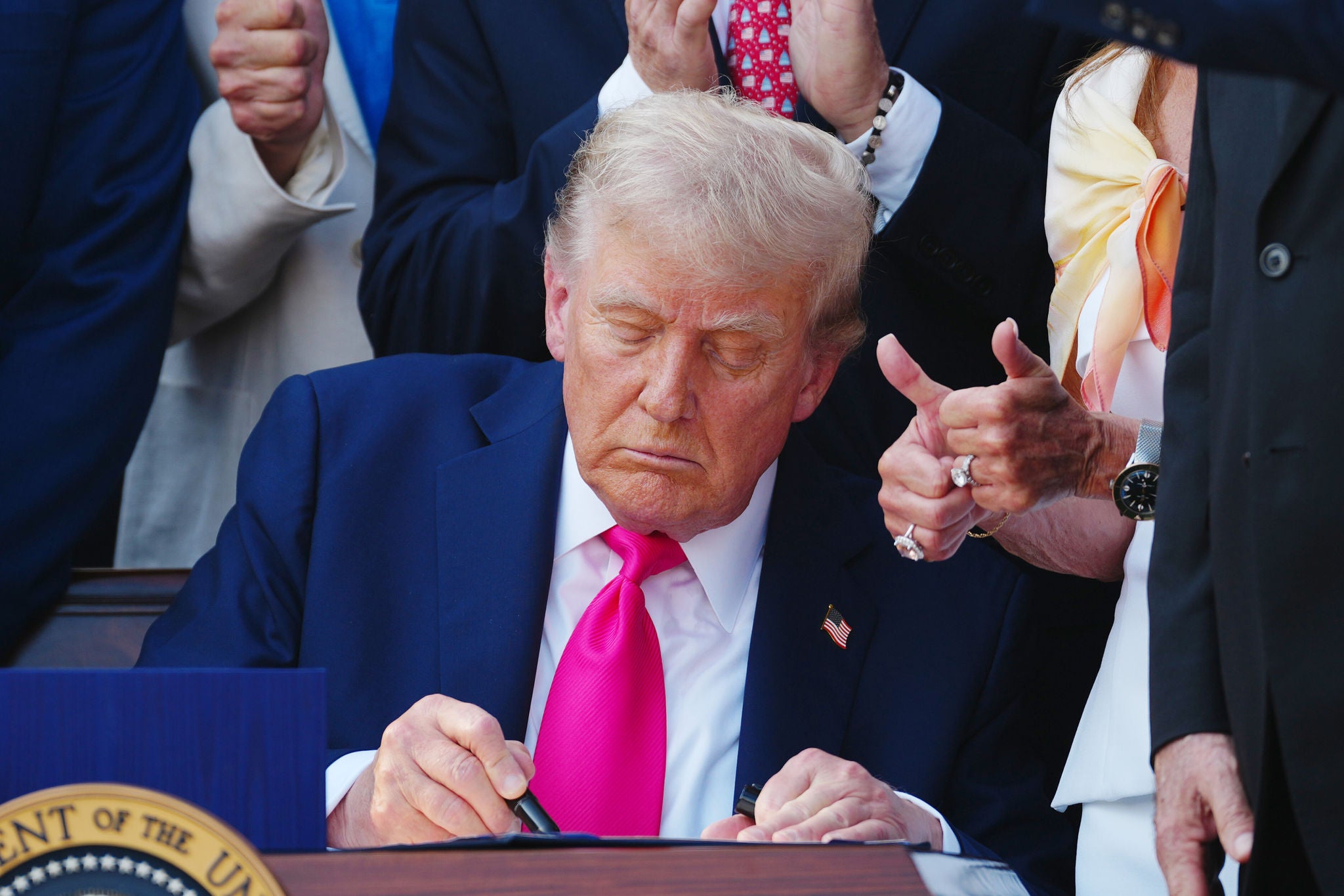 United States President Donald J Trump signs his  Big, Beautiful Bill,  with new tax and immigration legislation during a ceremony at the White House in Washington DC on Friday, July 4, 2025. The bill extends tax cuts from 2017, increases funding for defense and immigration security and cuts nearing $1 trillion from Medicaid.