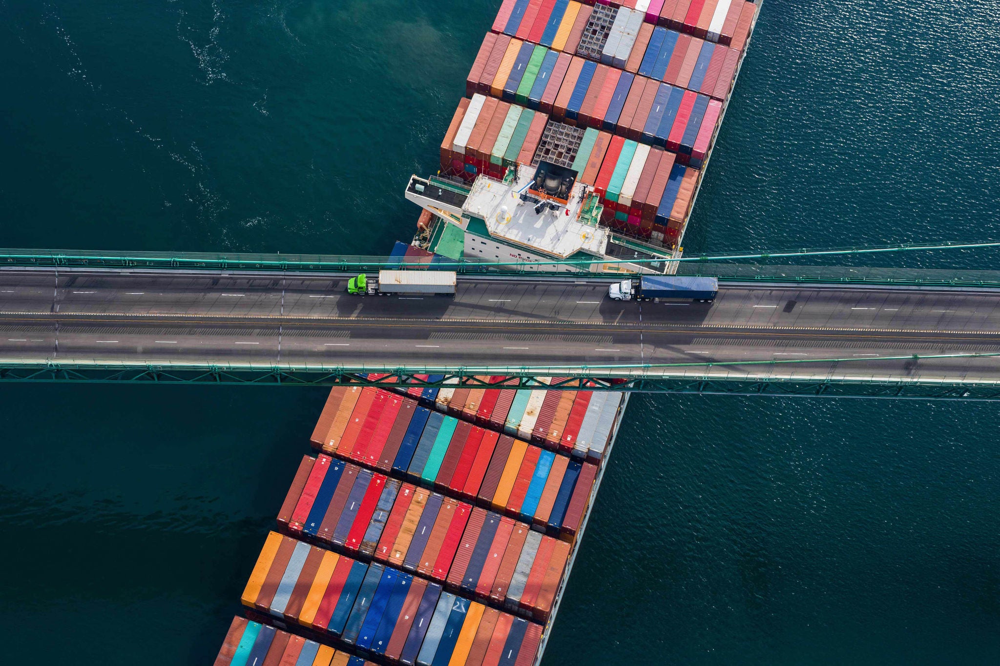 Large Container Ship crosses under a bridge at the port