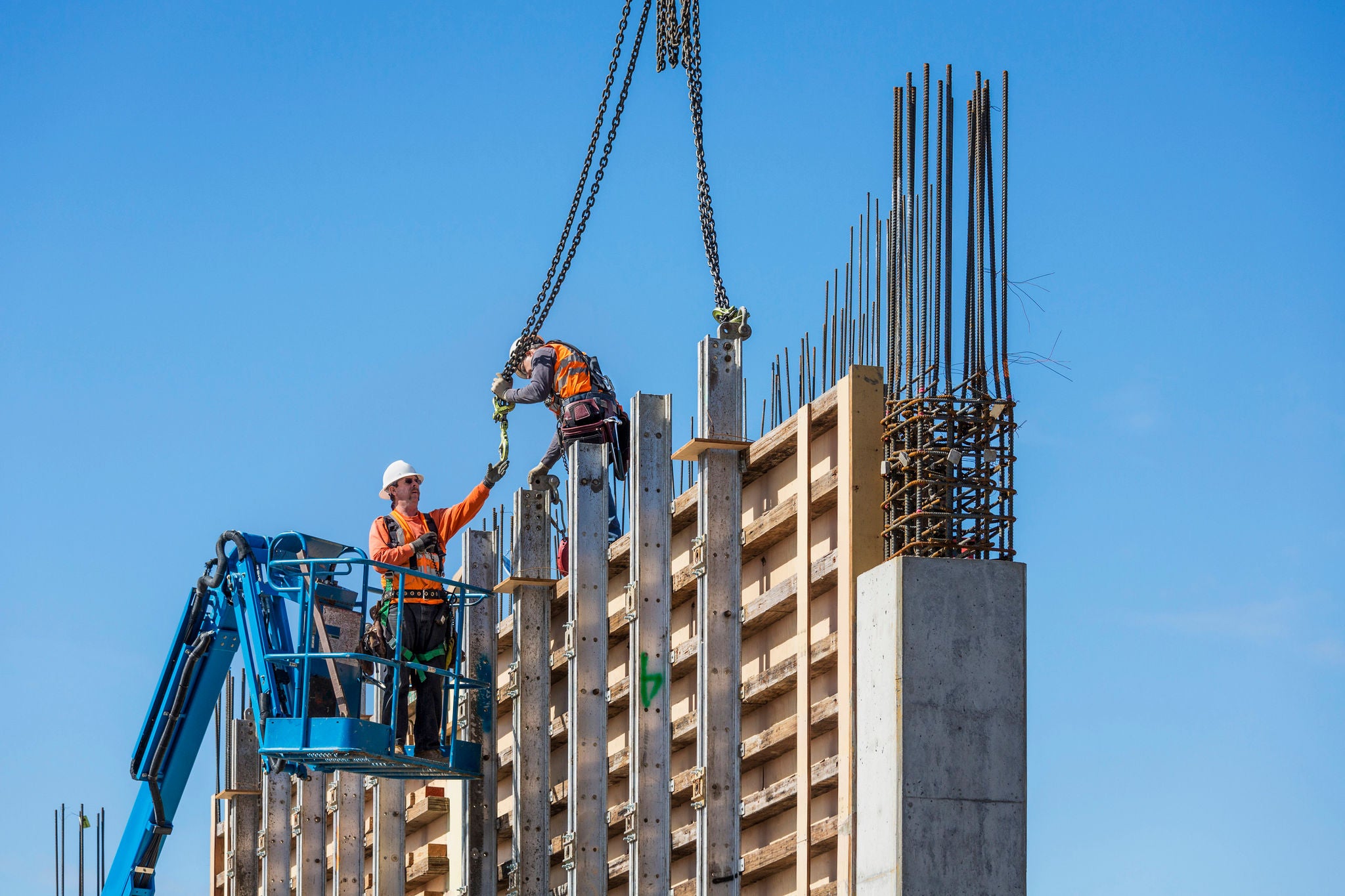 Workers on concrete wall form on construction site