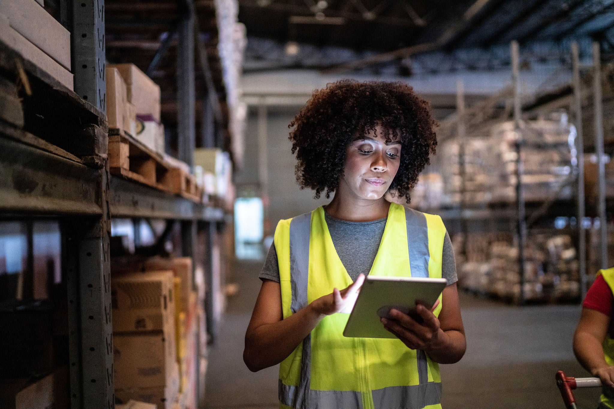 Young woman using the digital tablet in a warehouse