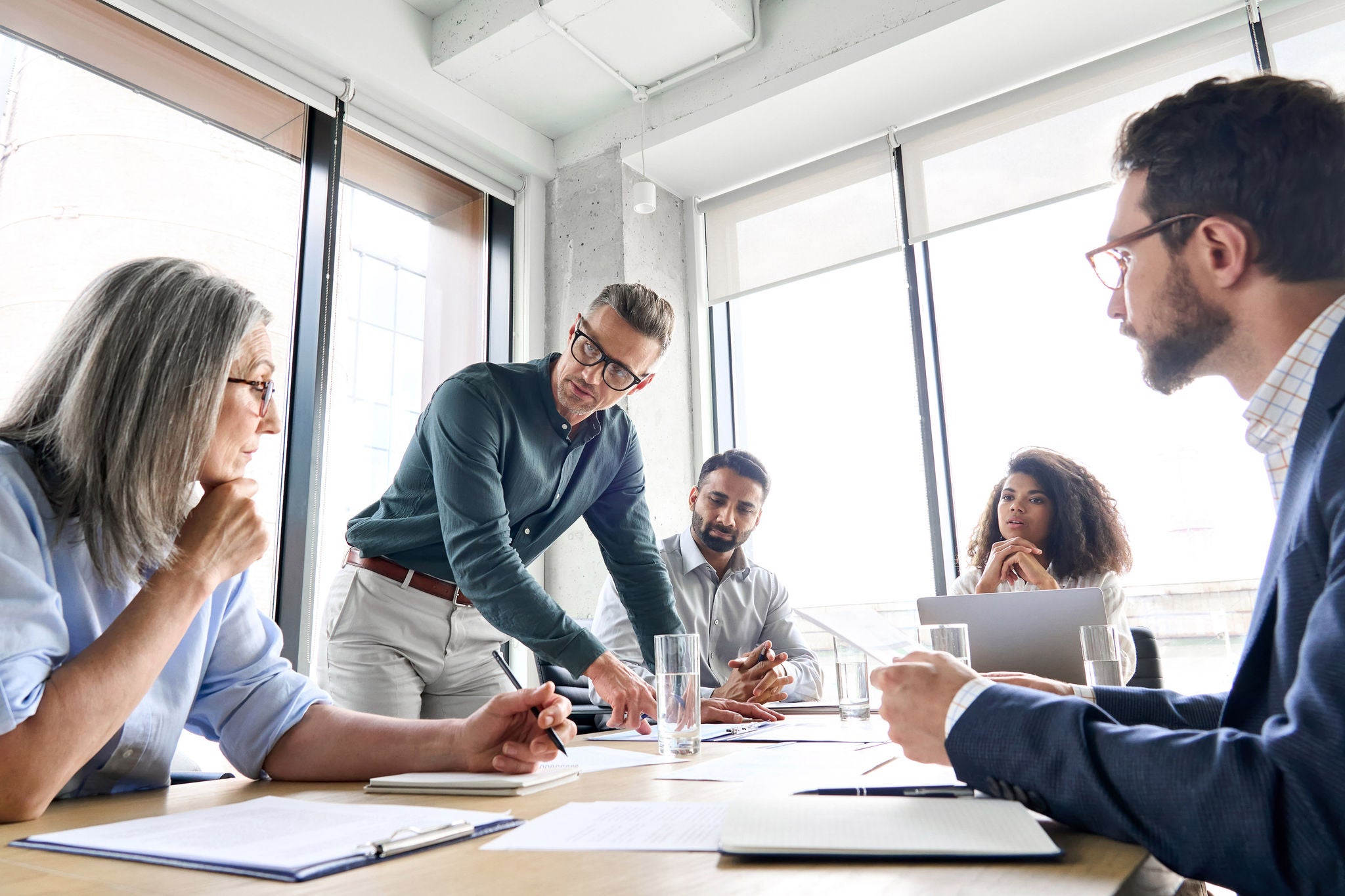 Group of colleagues having a meeting around a table and discussing documents