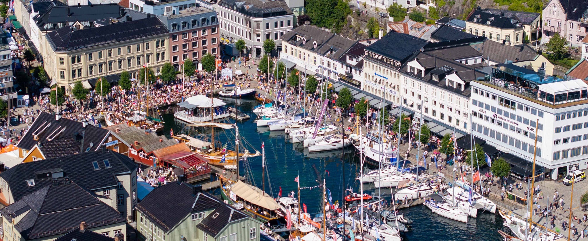 Luftfoto av Arendal sentrum med båter, folkeliv og tett bebyggelse under Arendalsuka. Photo cred: Media Service AS