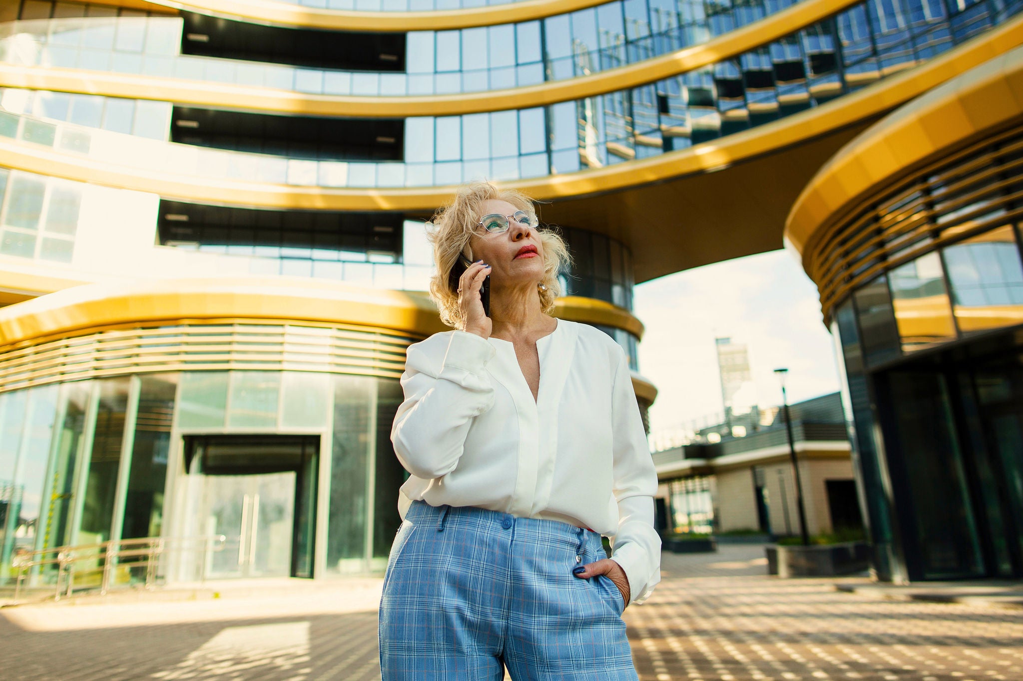 Senior businesswoman talking on mobile phone in front of office building