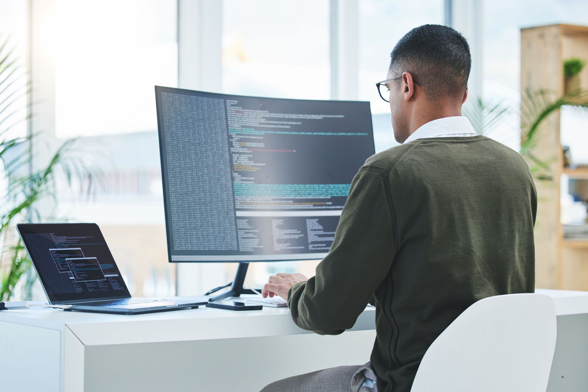 Technician working on a coding software in office
