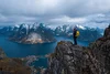 Senderista con mochila disfrutando del paisaje del atardecer en Lofoten, Noruega
