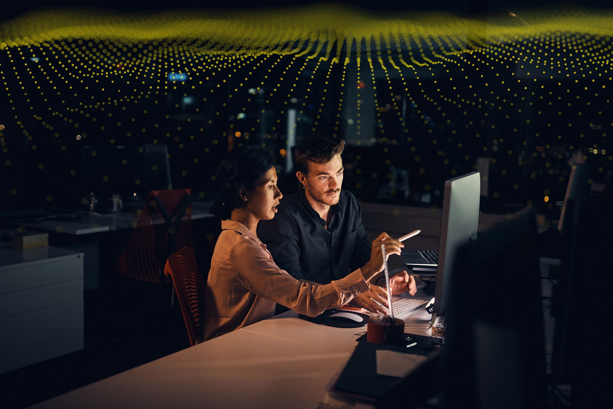 Shot of two businesspeople working late in an office