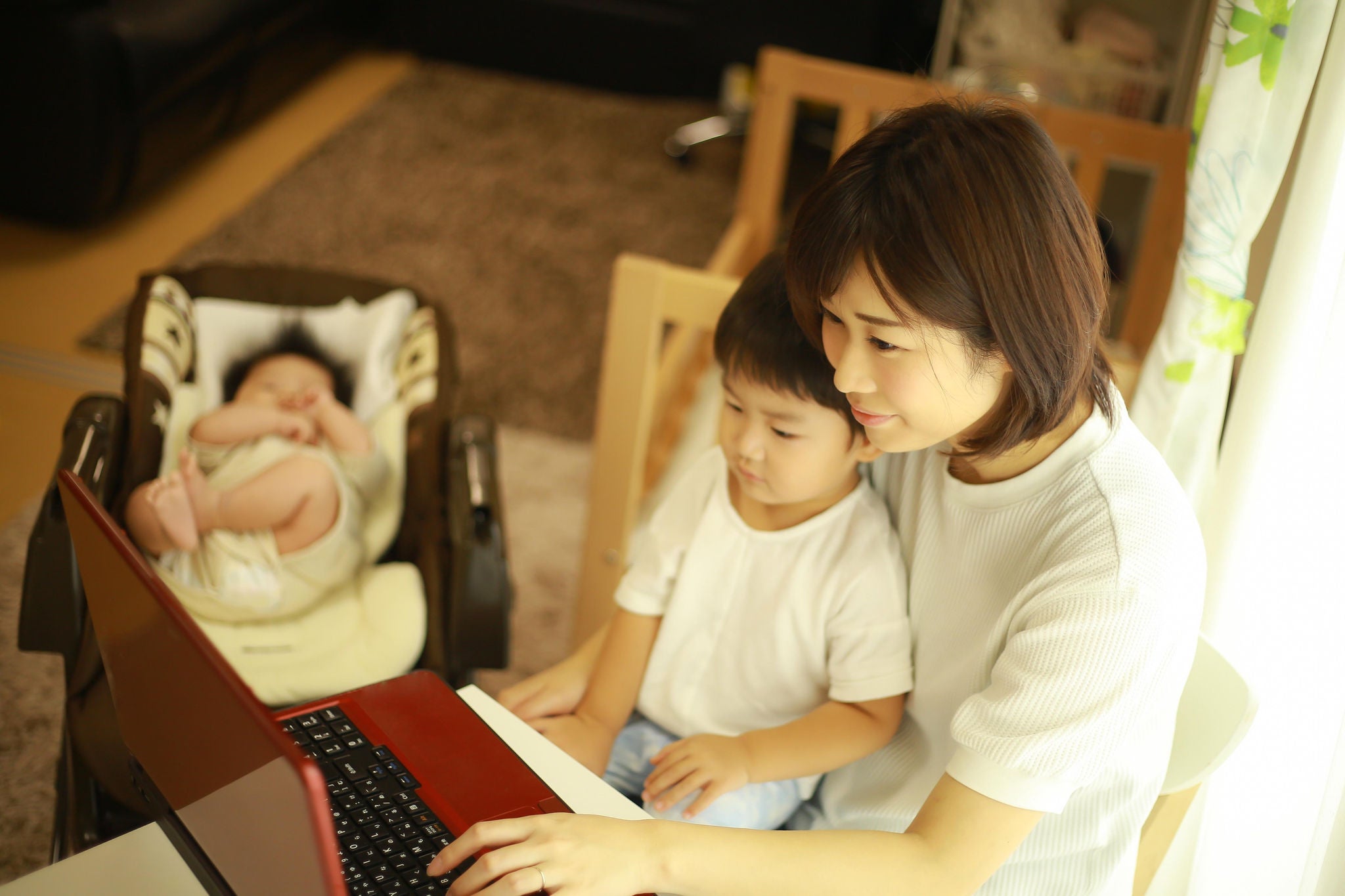 Mother and child at laptop with baby 