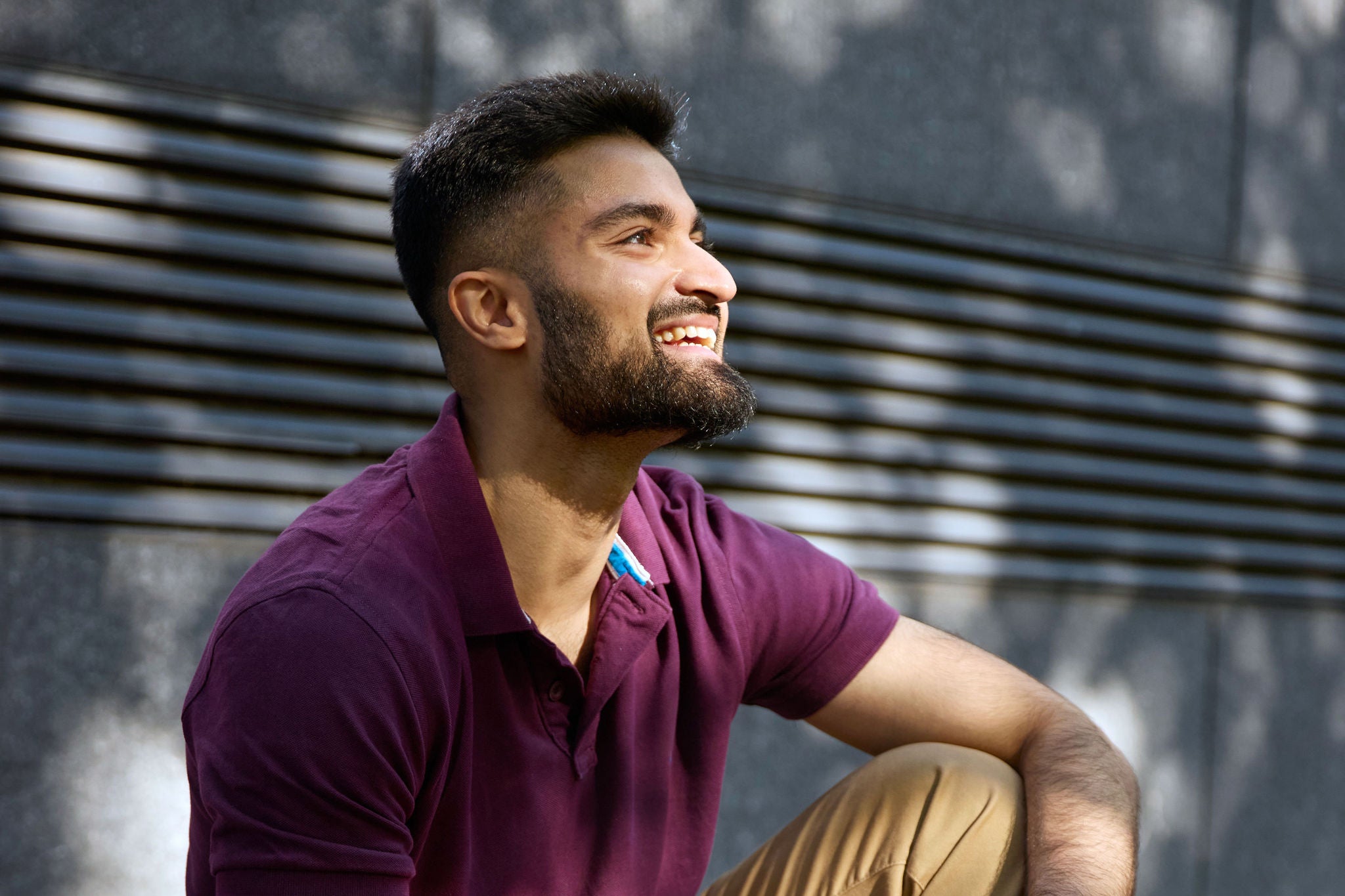 Person sitting on the road looking up at the sun