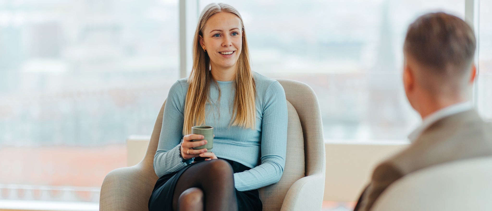 Professional seated discussing ideas in a relaxed office lounge setting