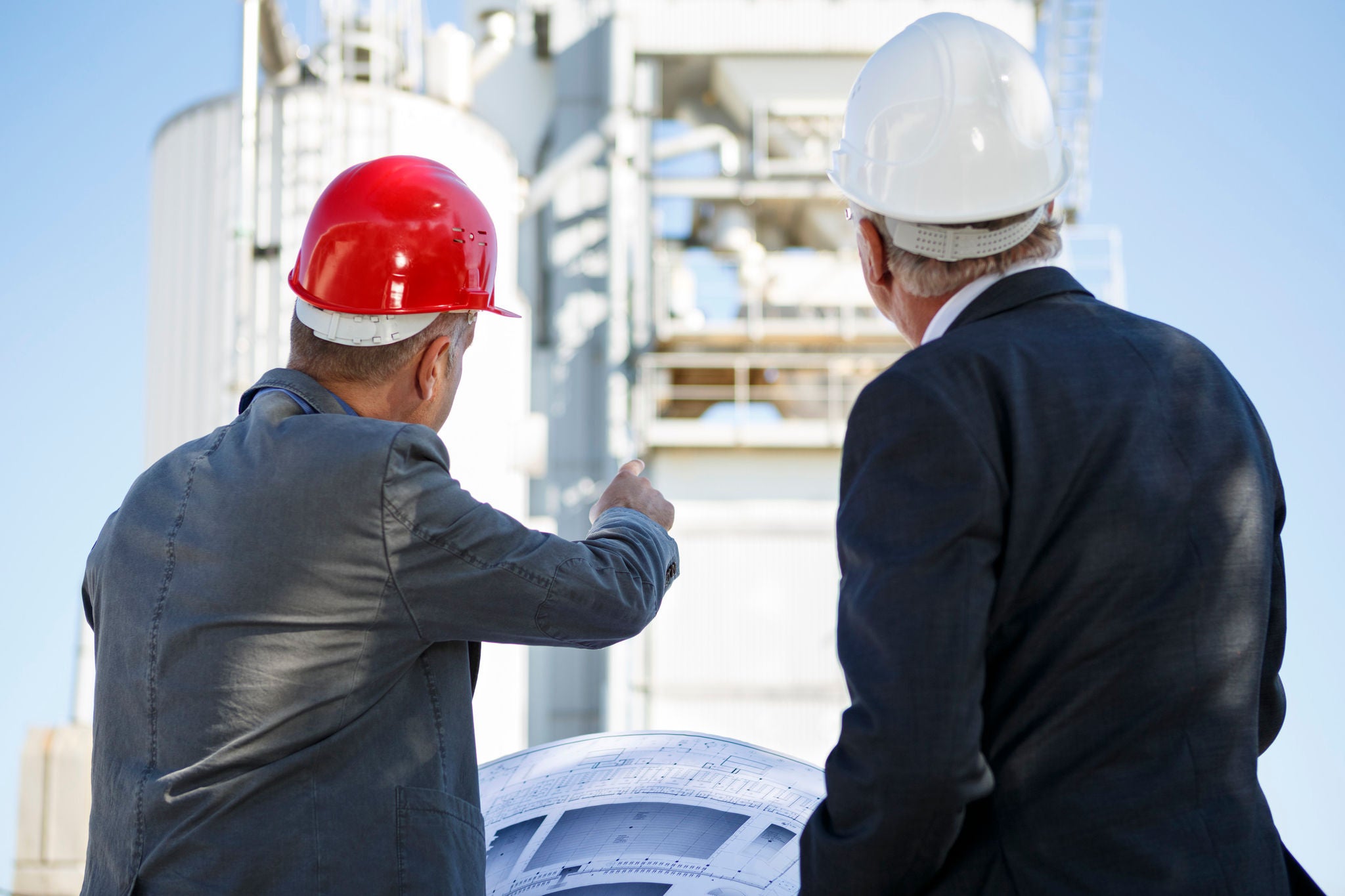 To ingeniører i jakkesæt inspicerer industrifaciliteter