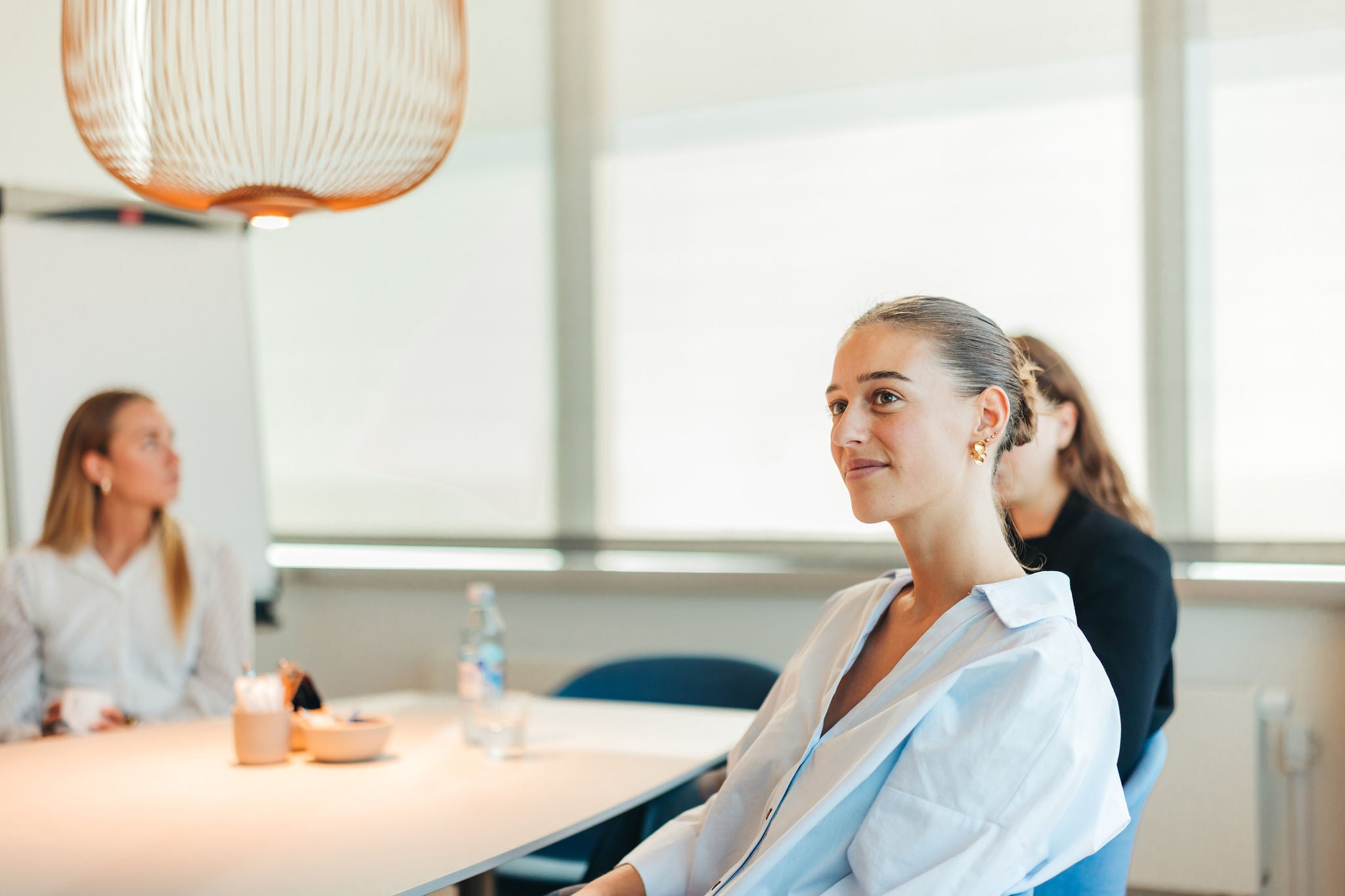 Professional listening during team meeting in modern office setting