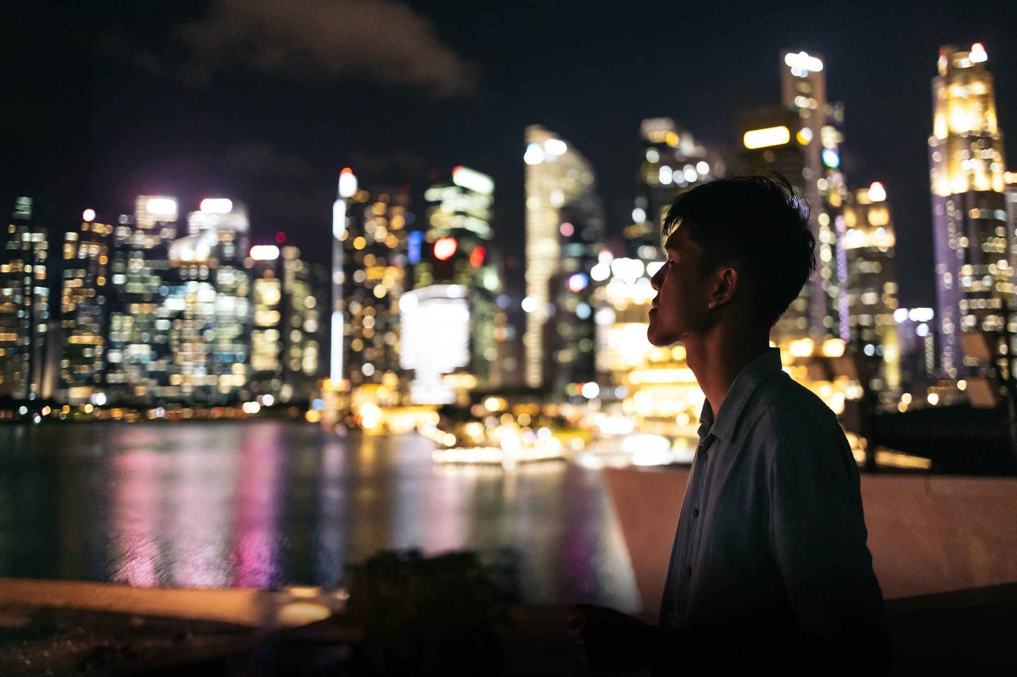 Asian man watching the Singapore skyline at night