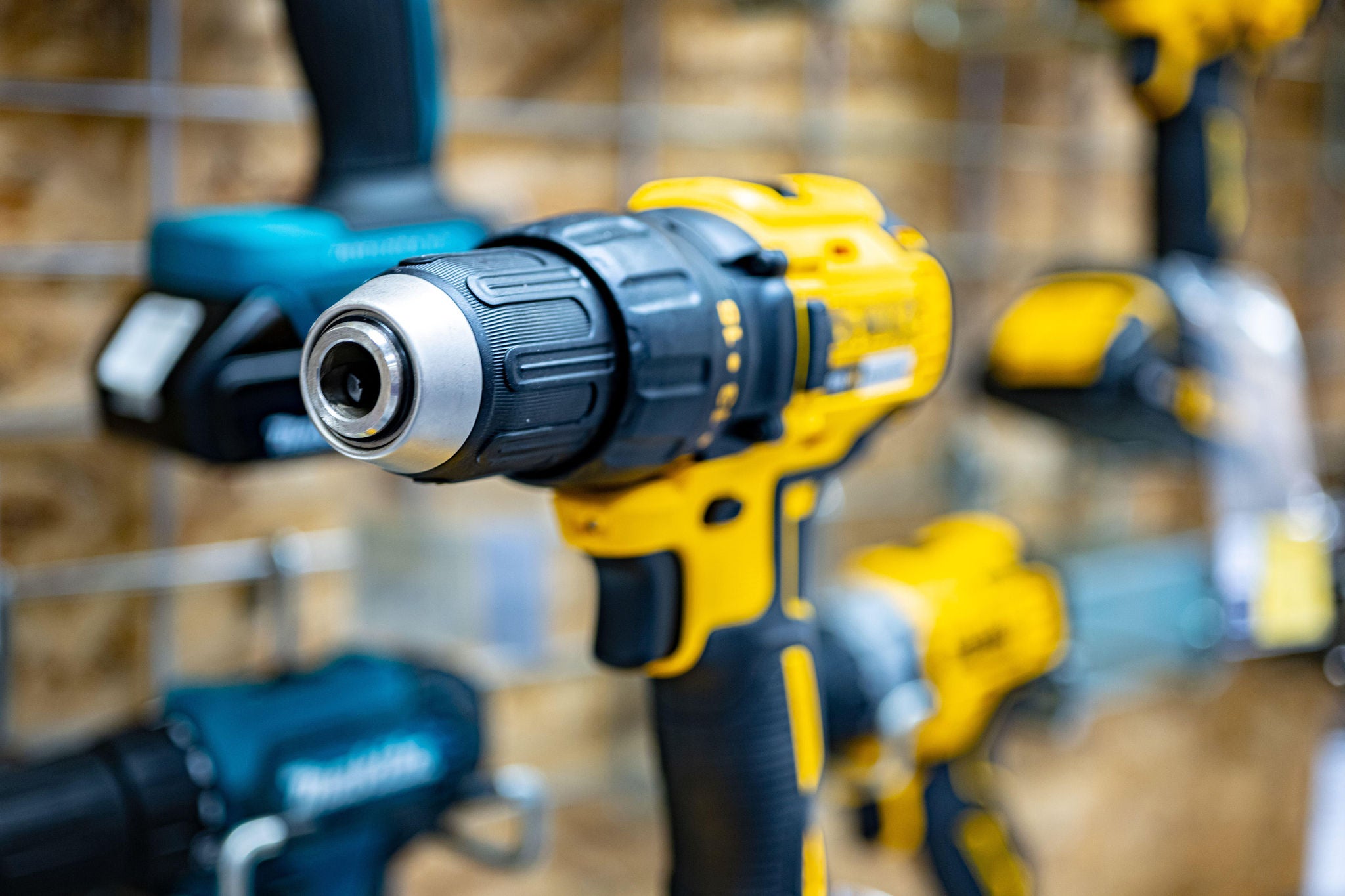 Gelber Akkubohrer n einem Baumarkt vor einer Wand mit weiteren anderen