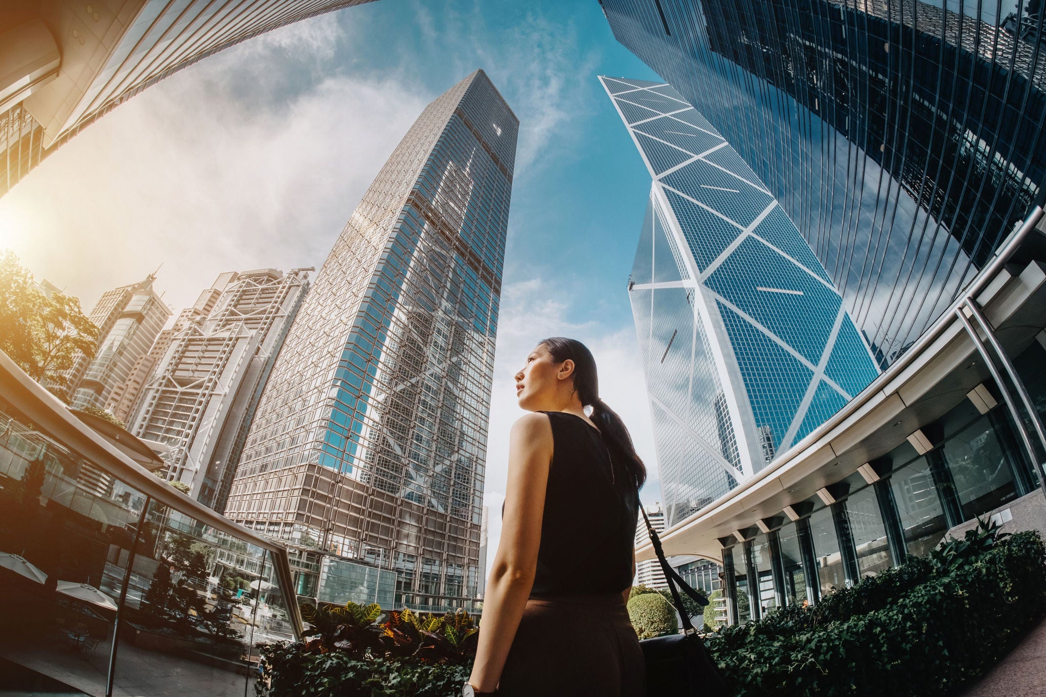  Asian businesswoman looking at highrise towers