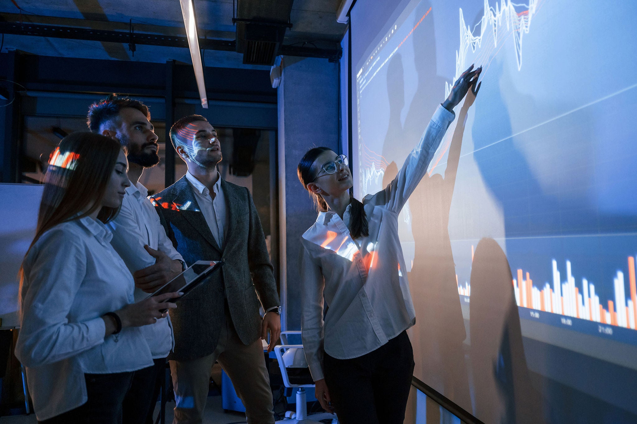 Equipe analysant donnees financieres sur grand ecran