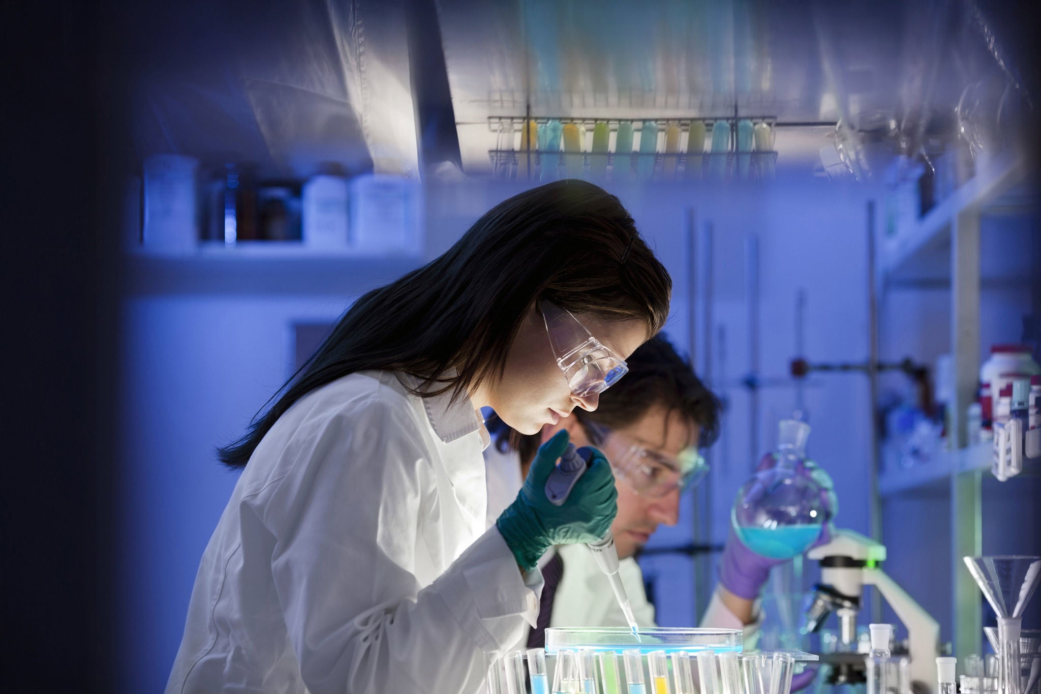 scientist, doctor, asistent working at the laboratory using pipette
