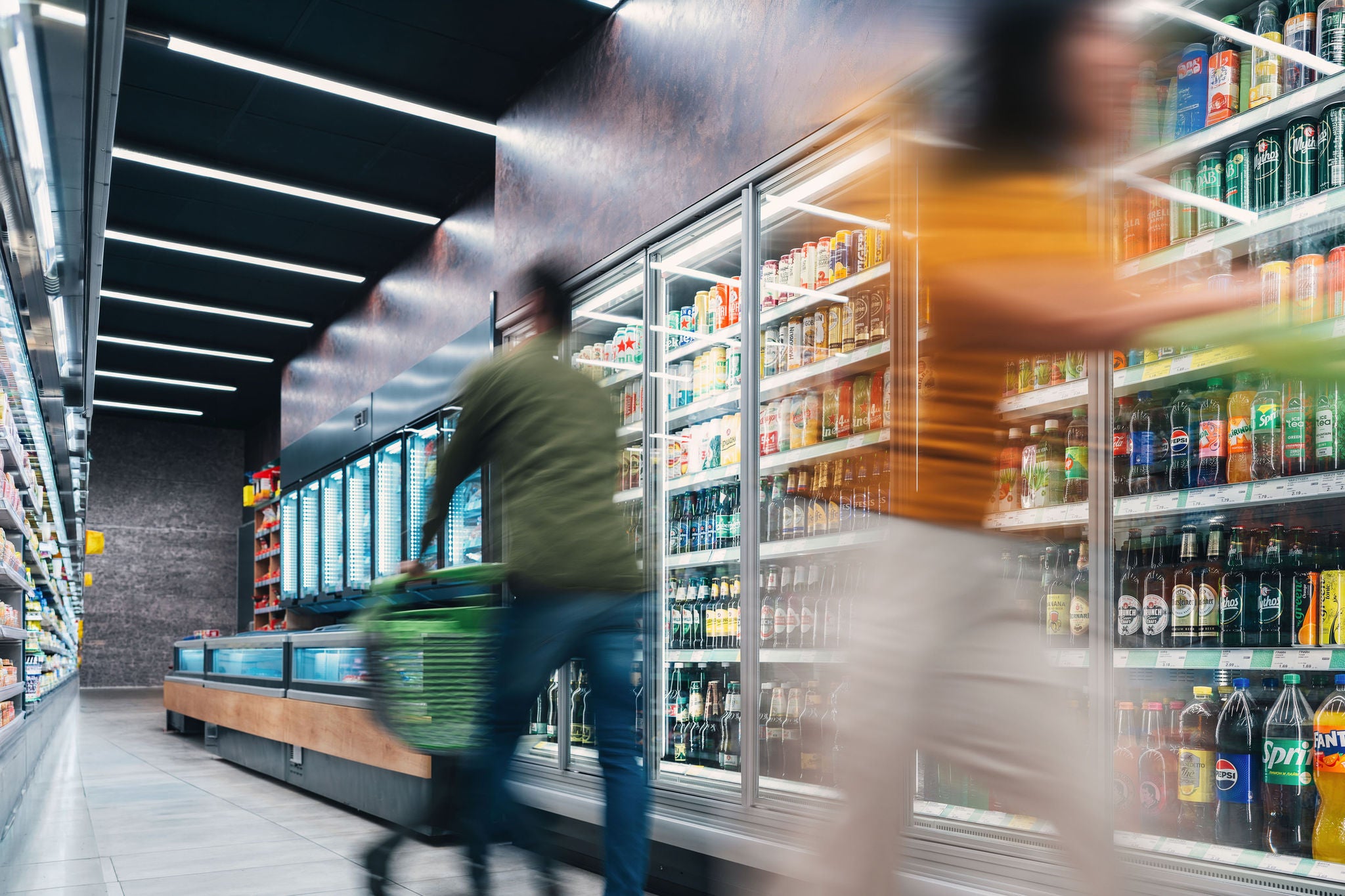 Busy customers pushing shopping cart at the supermarket