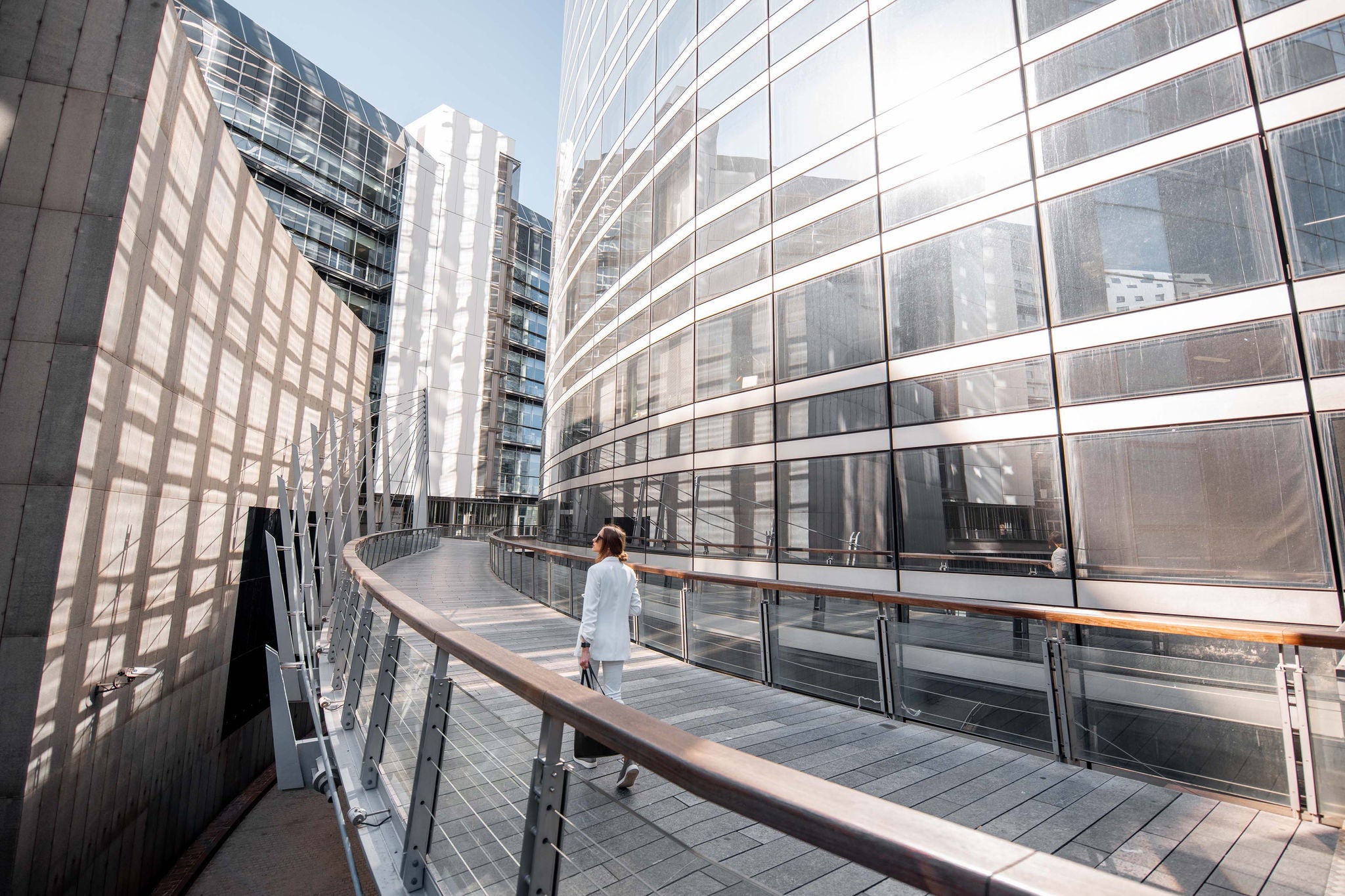 Business woman walking outdoors at the financial district with modern buildings on the background in Paris