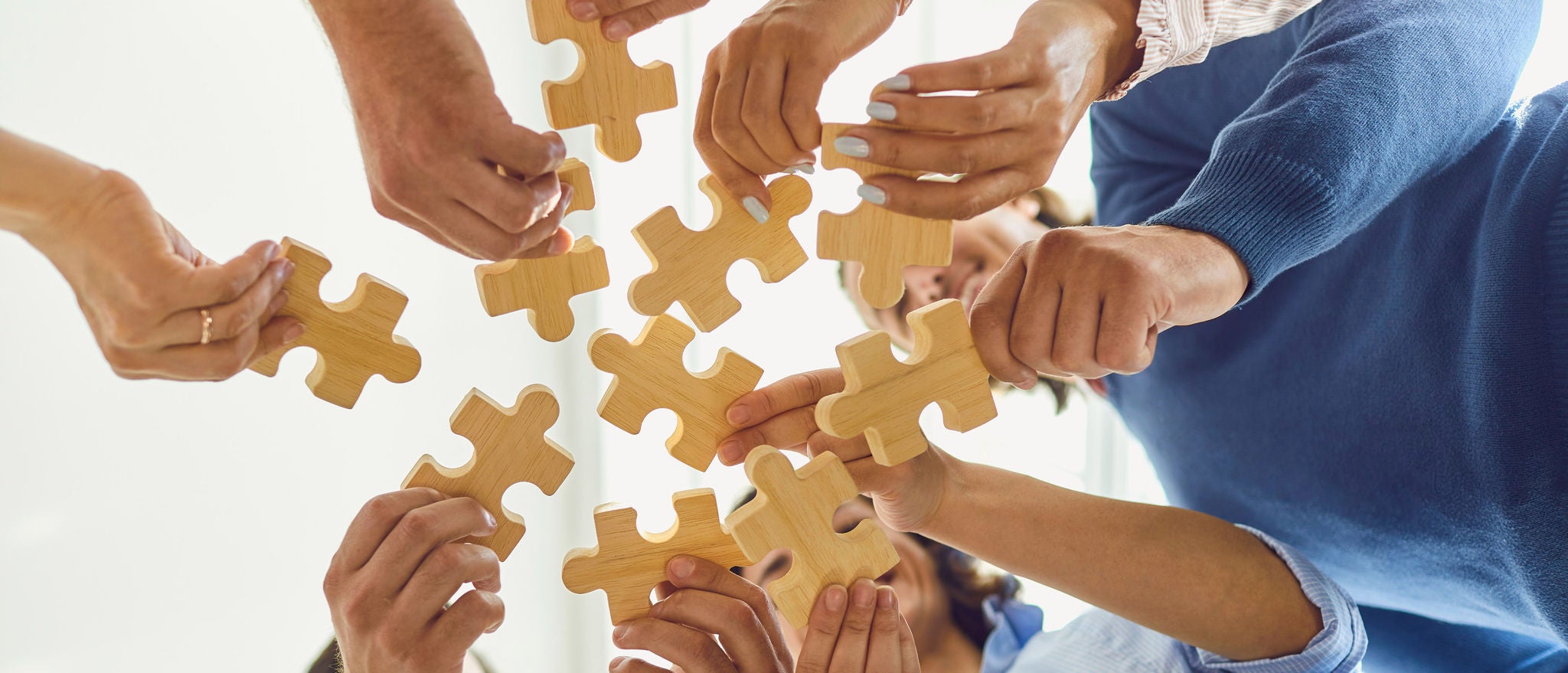 Ansatte samarbeider om puslespill under teambuilding, som del av HR-transformasjon for å styrke samarbeid og kulturendring.