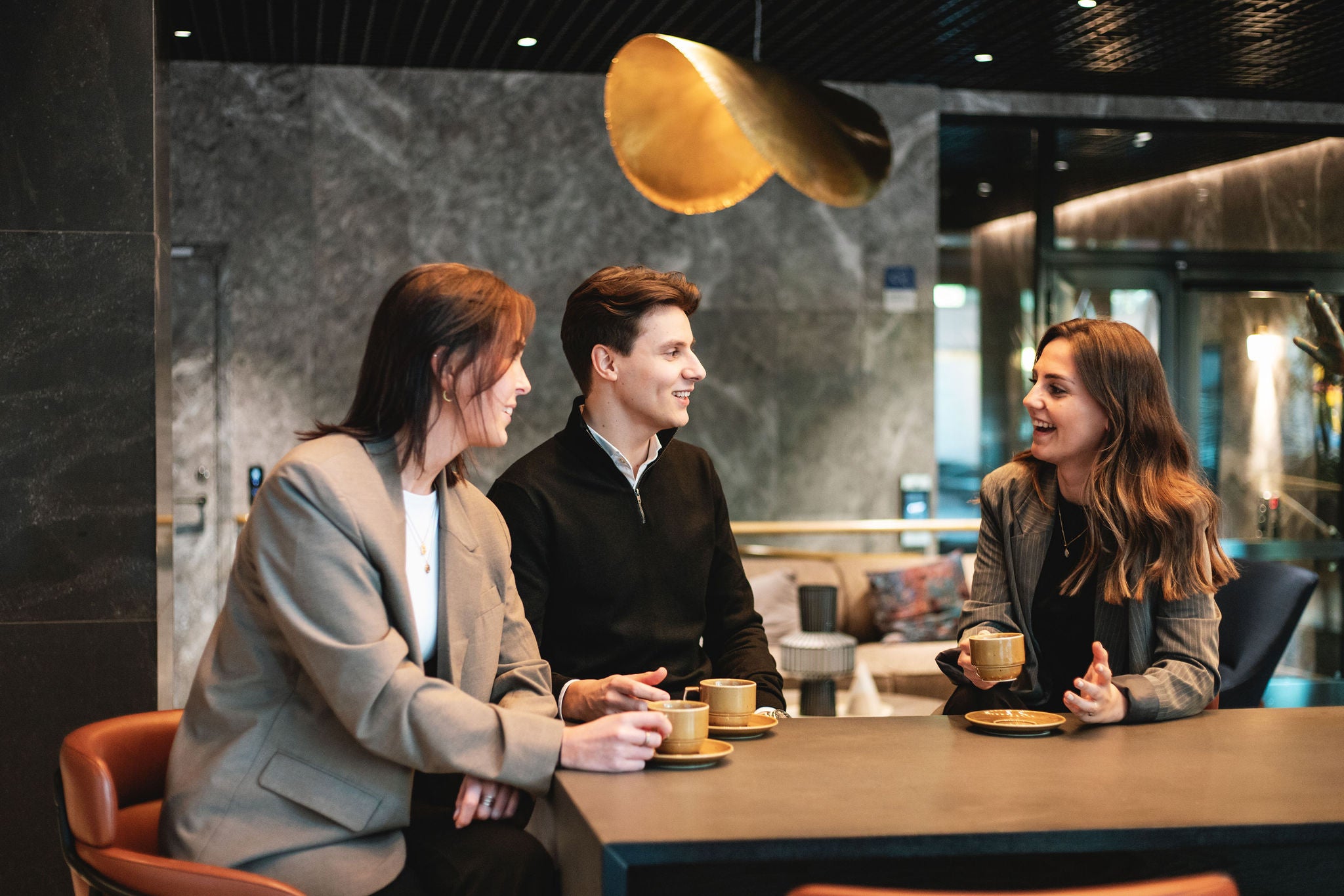 Team discussing ideas over coffee in modern office lounge setting