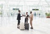 Wide shot business colleagues greeting in airport arrival terminal