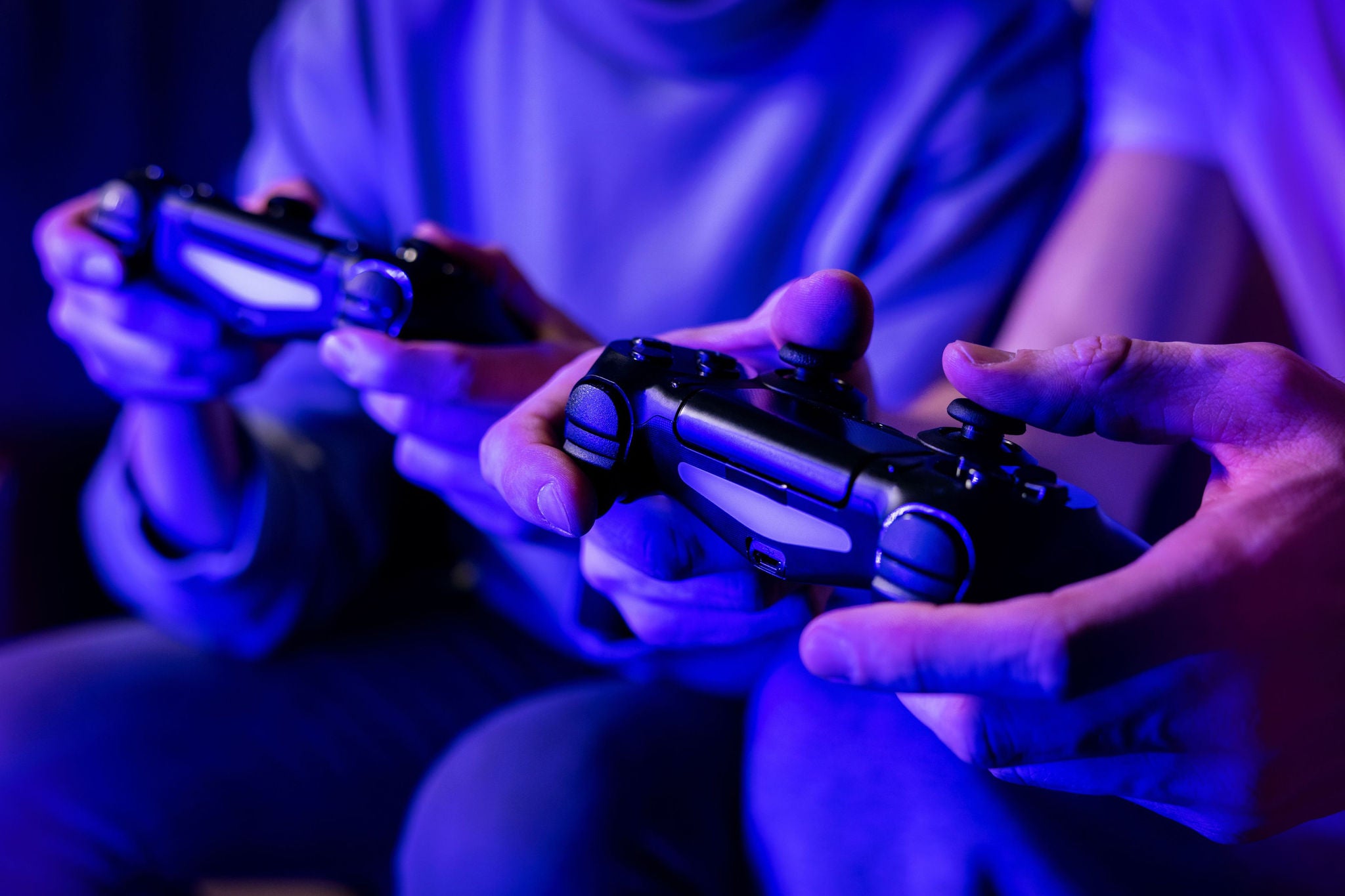 Deux personnes jouent aux jeux vidéo avec des manettes bleues
