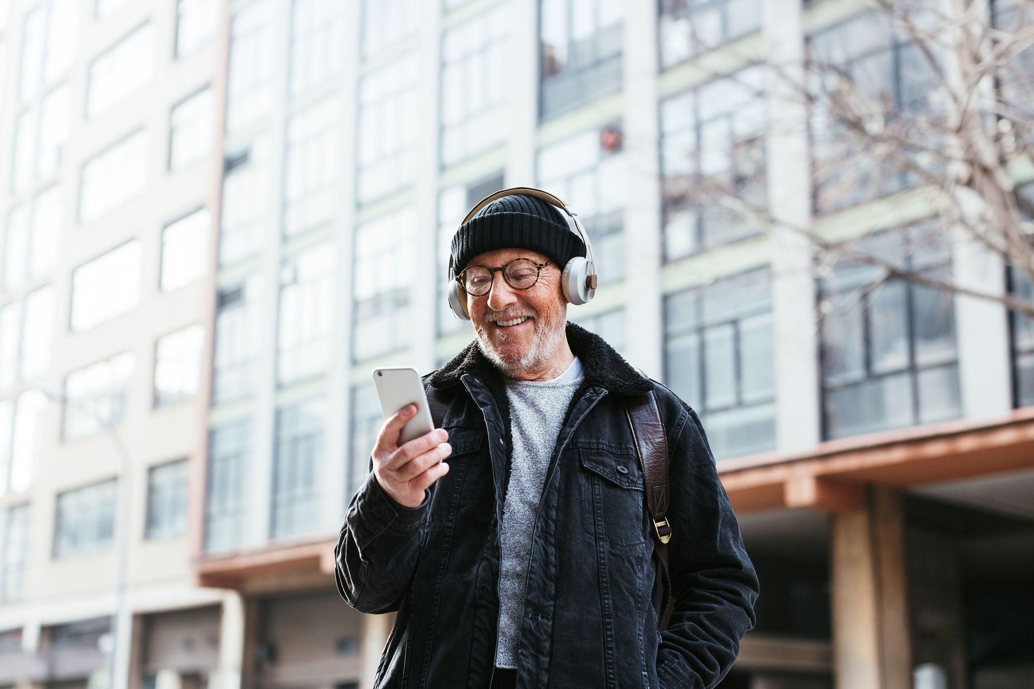 older man smiling while looking at smartphone