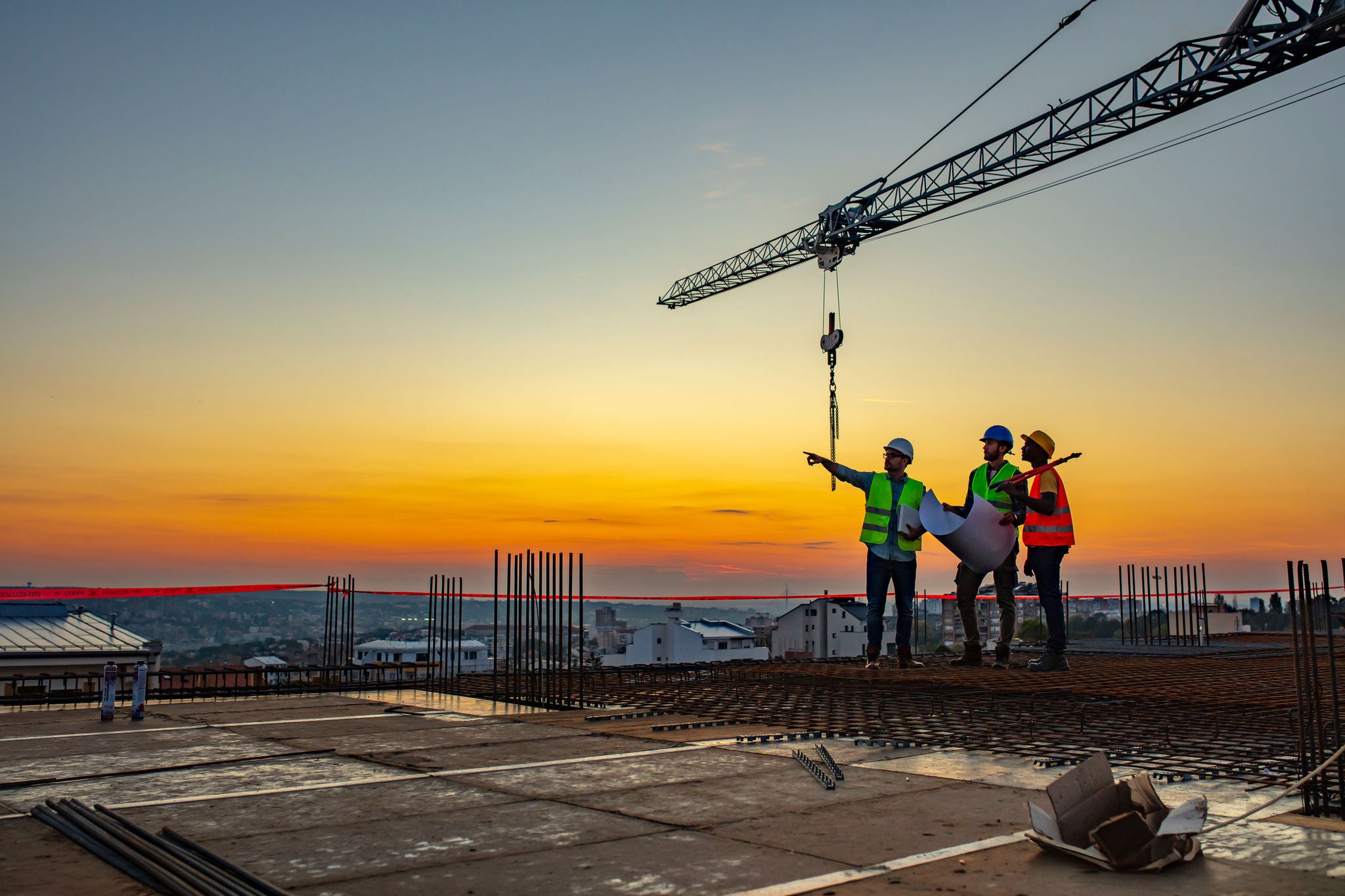 Workers talking at construction site reviewing plans