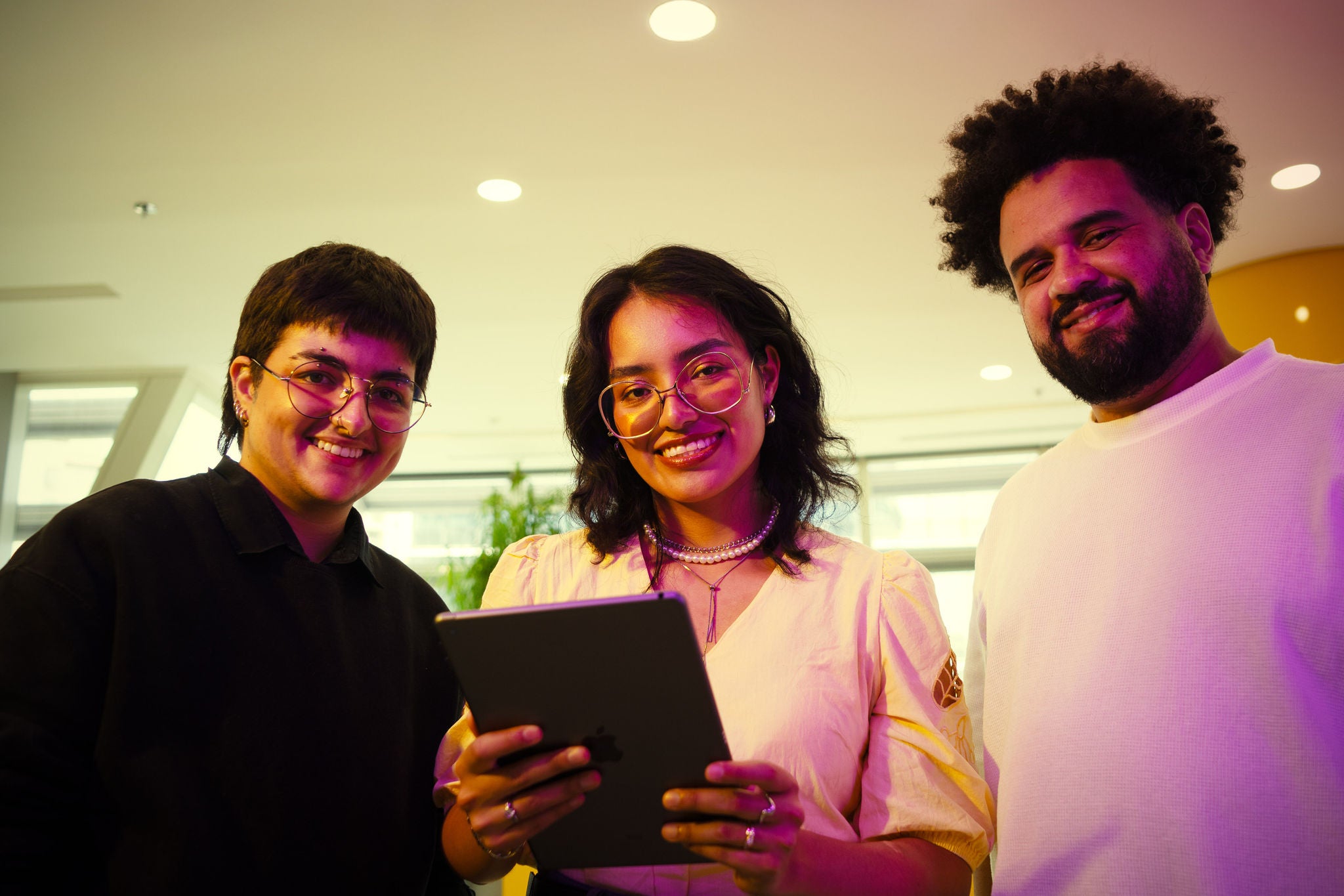 Tres personas sonrientes mirando a cámara