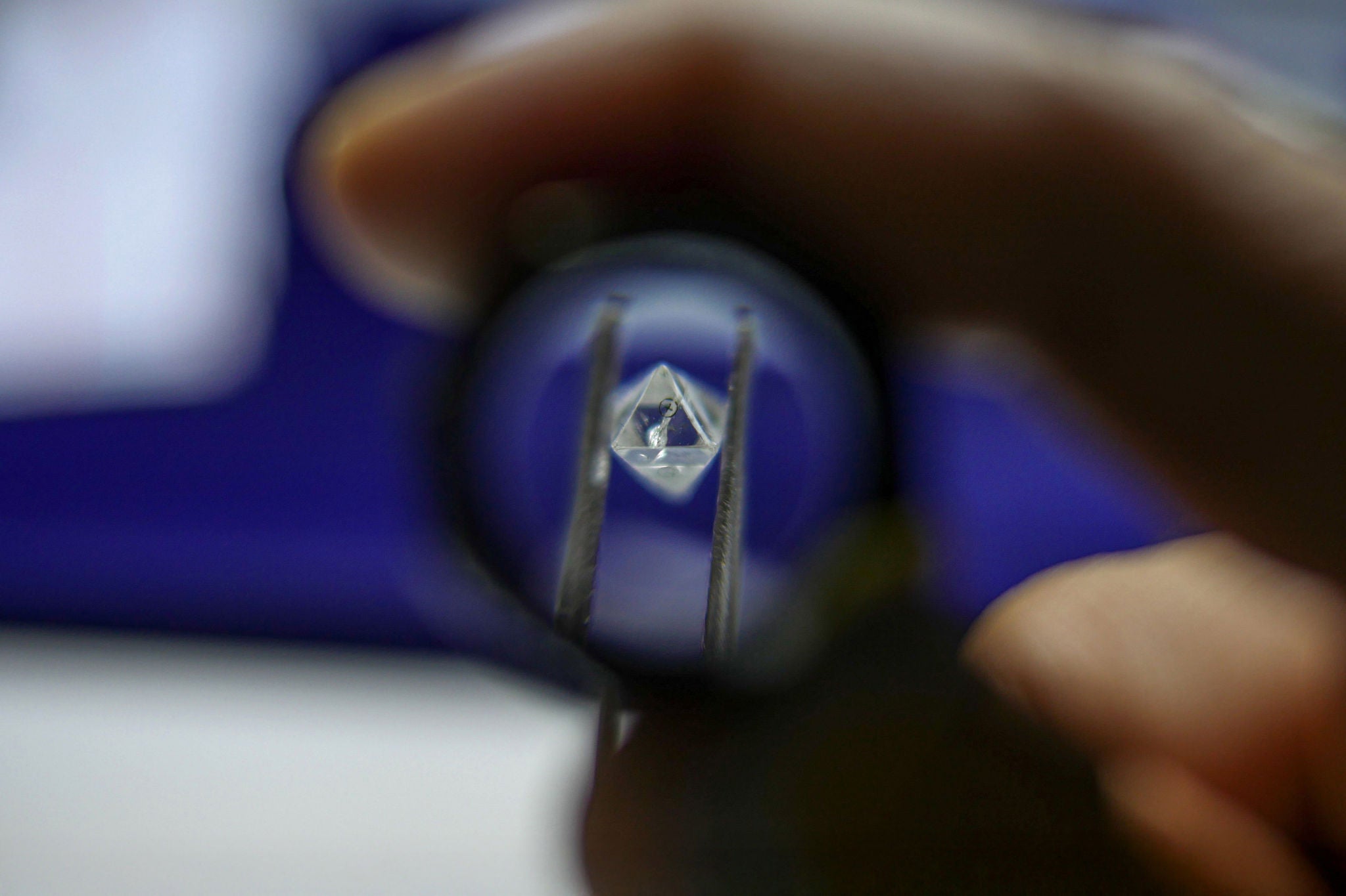 A worker inspects a rough diamond in a workshop in India. Photographer: Dhiraj Singh/Bloomberg