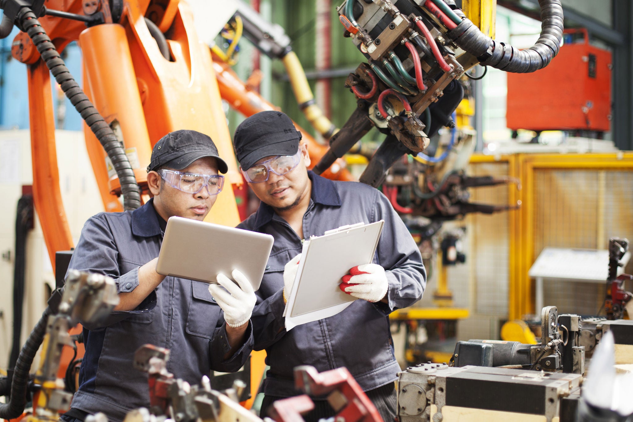 Twee medewerkers controleren productiedata op een tablet en een notitieblok