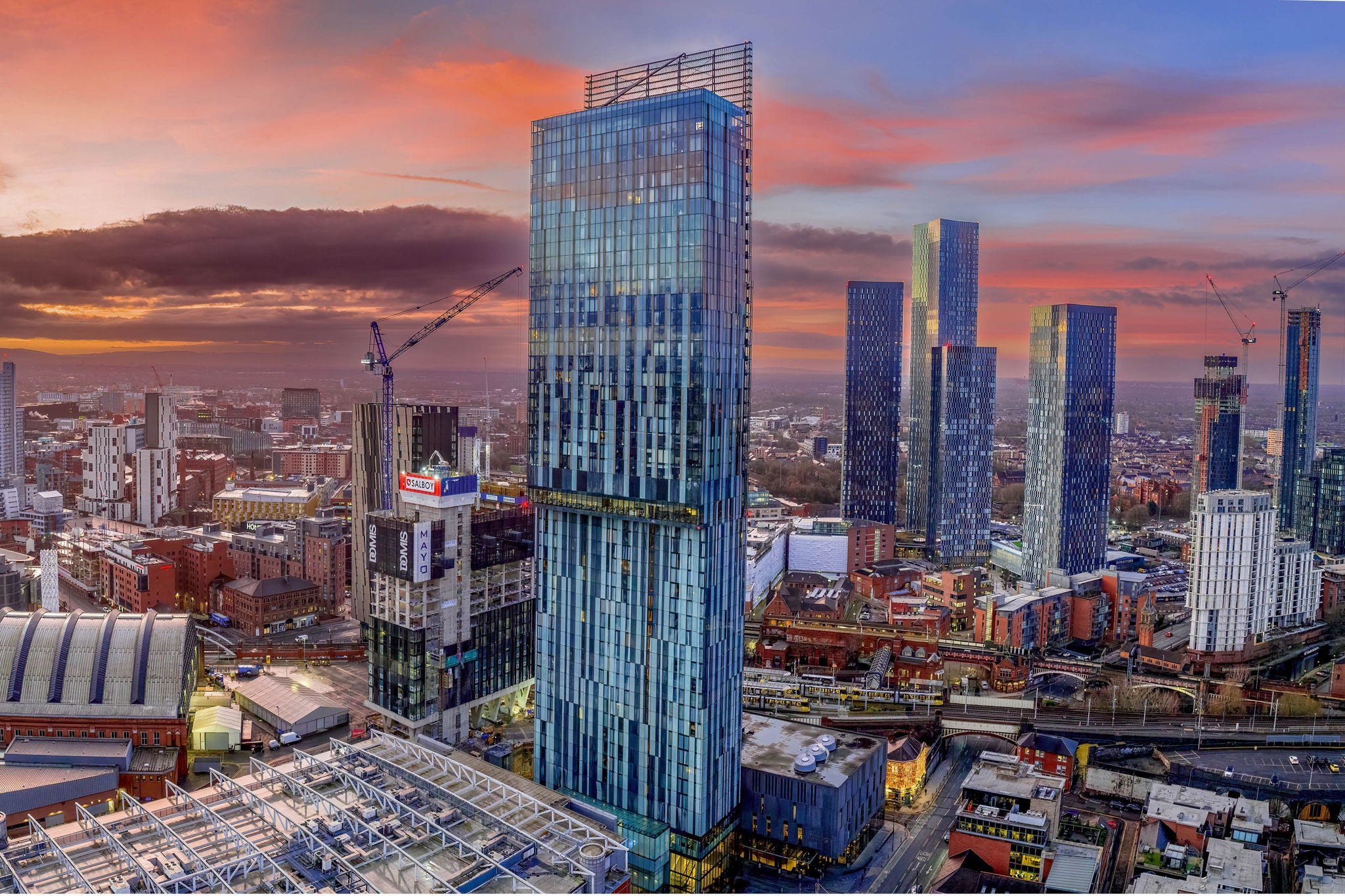Aerial view of modern commercial and residential high-rise buildings within a city centre skyline at sunset.