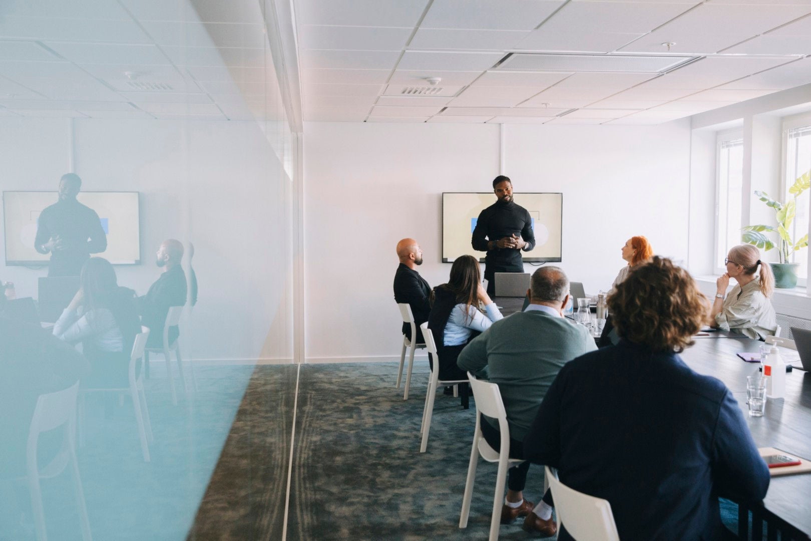 homem negro fala em uma apresentação para a sua equipe.