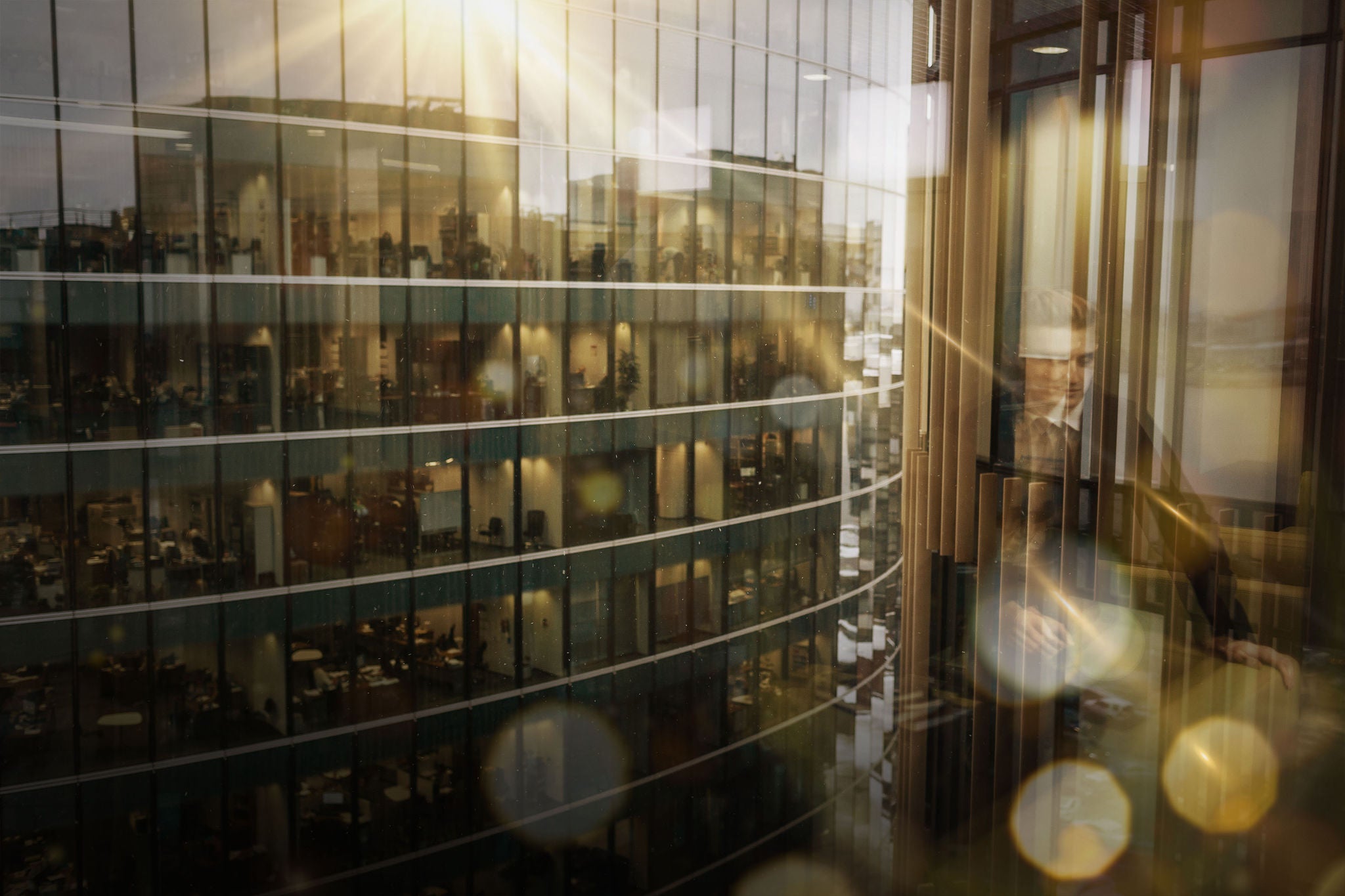 View across glass office buildings with people working inside